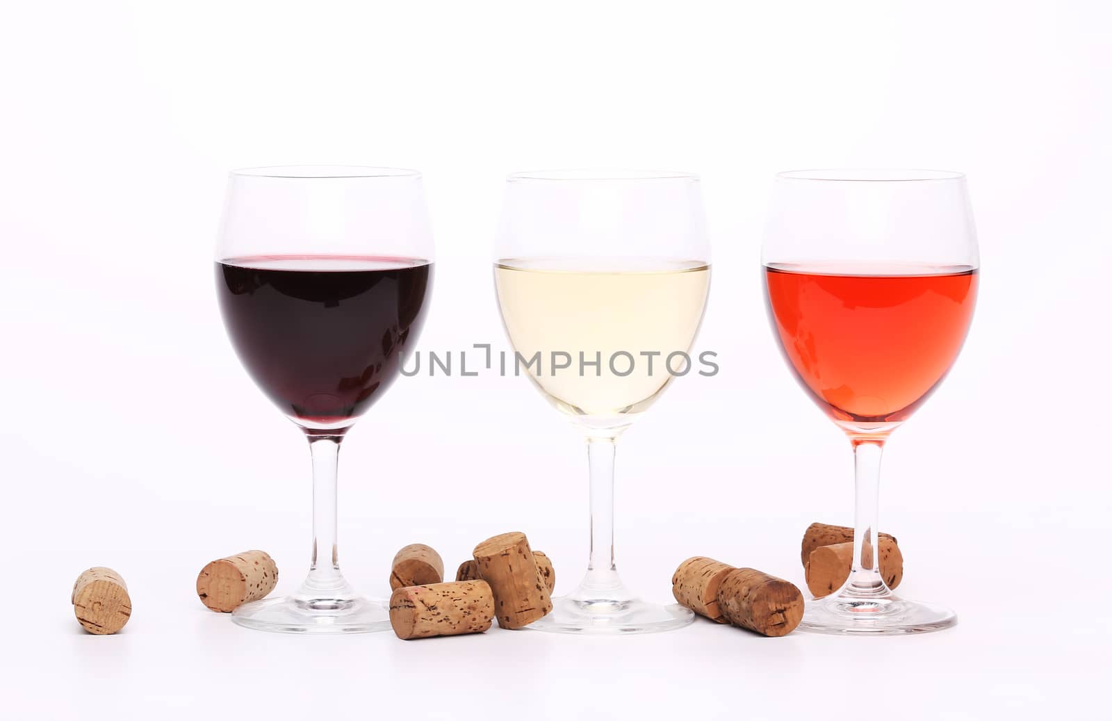 Three wine glasses and corks on the background.