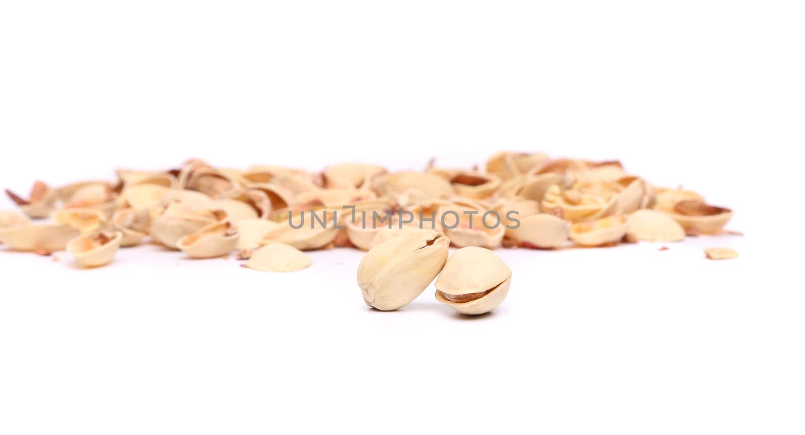 Two pistachios and peel on the white background.