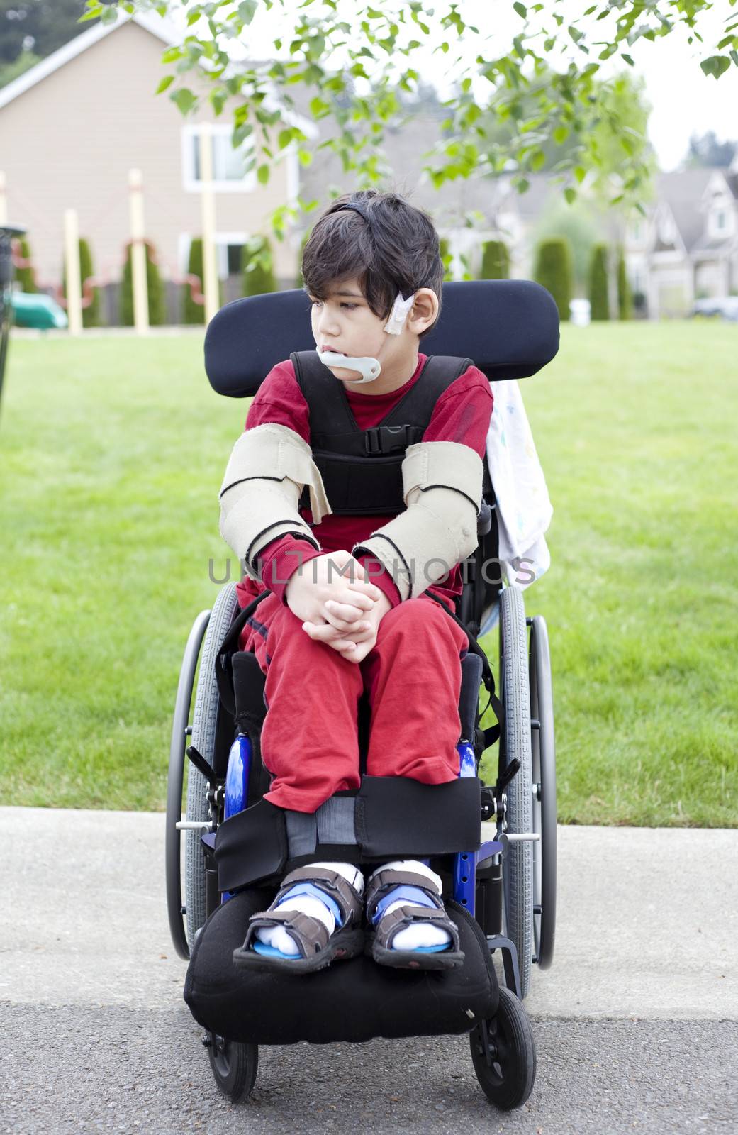 Disabled little boy in wheelchair outdoors  by jarenwicklund