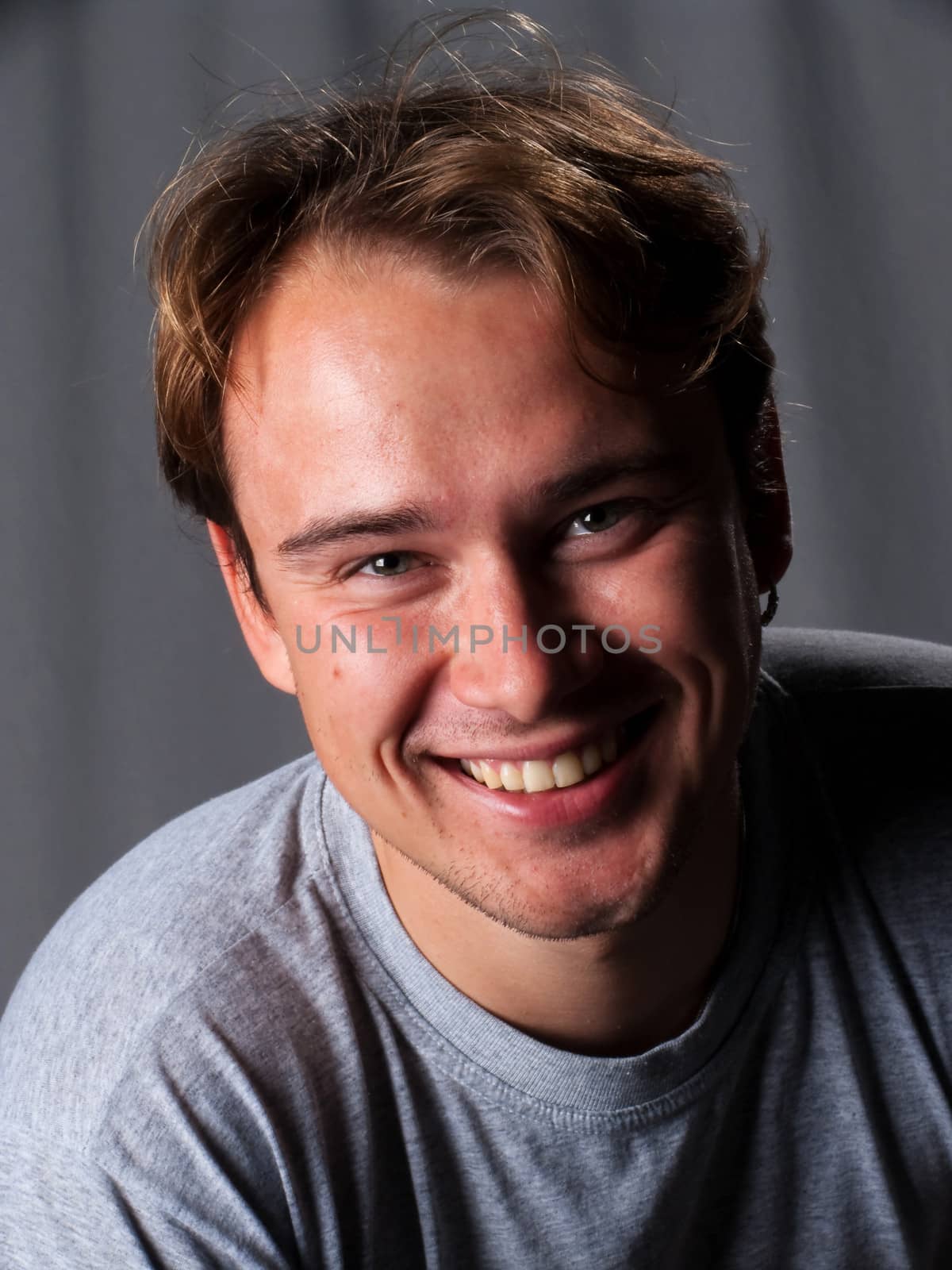portrait of young handsome smiling man in studio