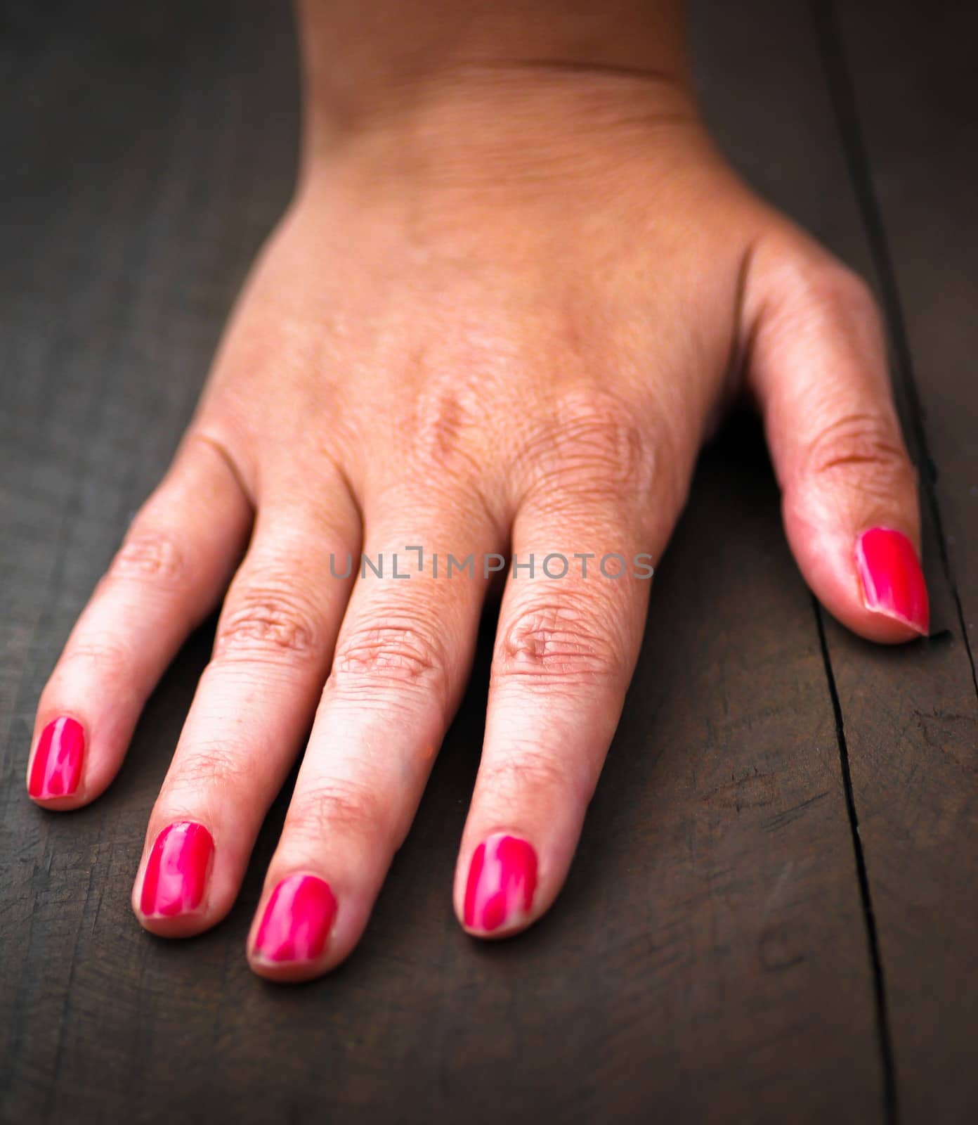 right hand of a caucasian woman with a wooden background