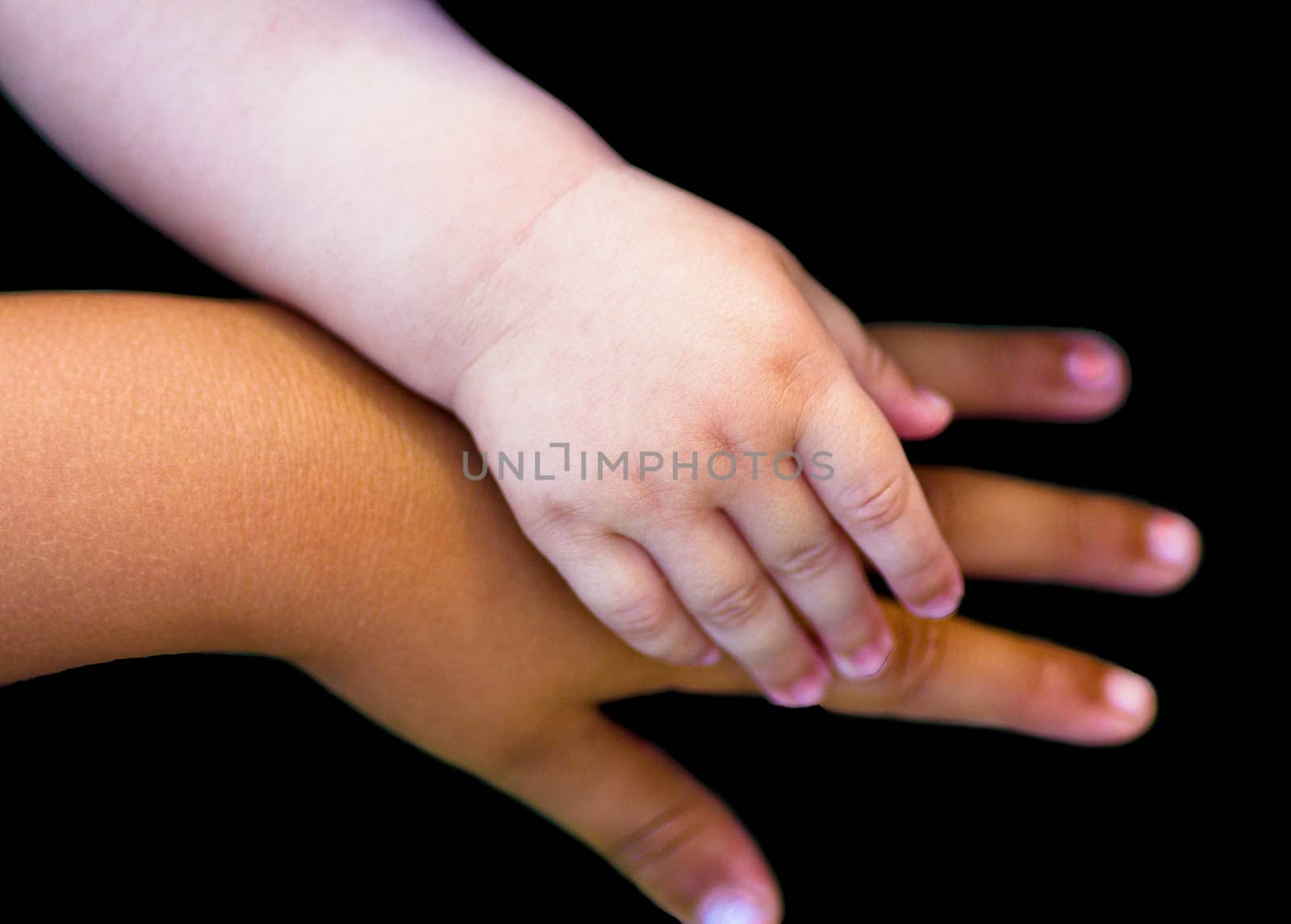 two child hands isolated on black