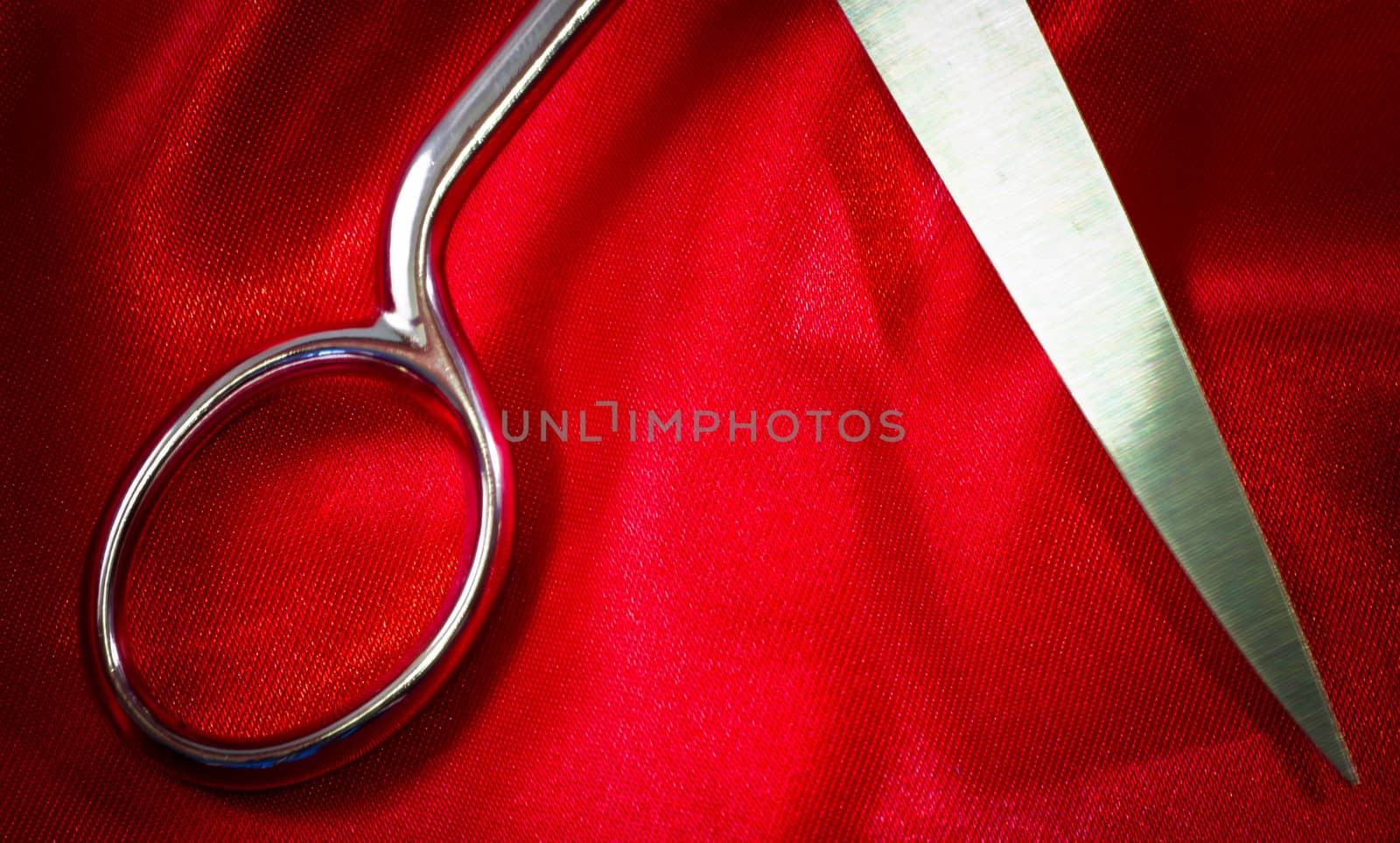 steel scissors on red fabric