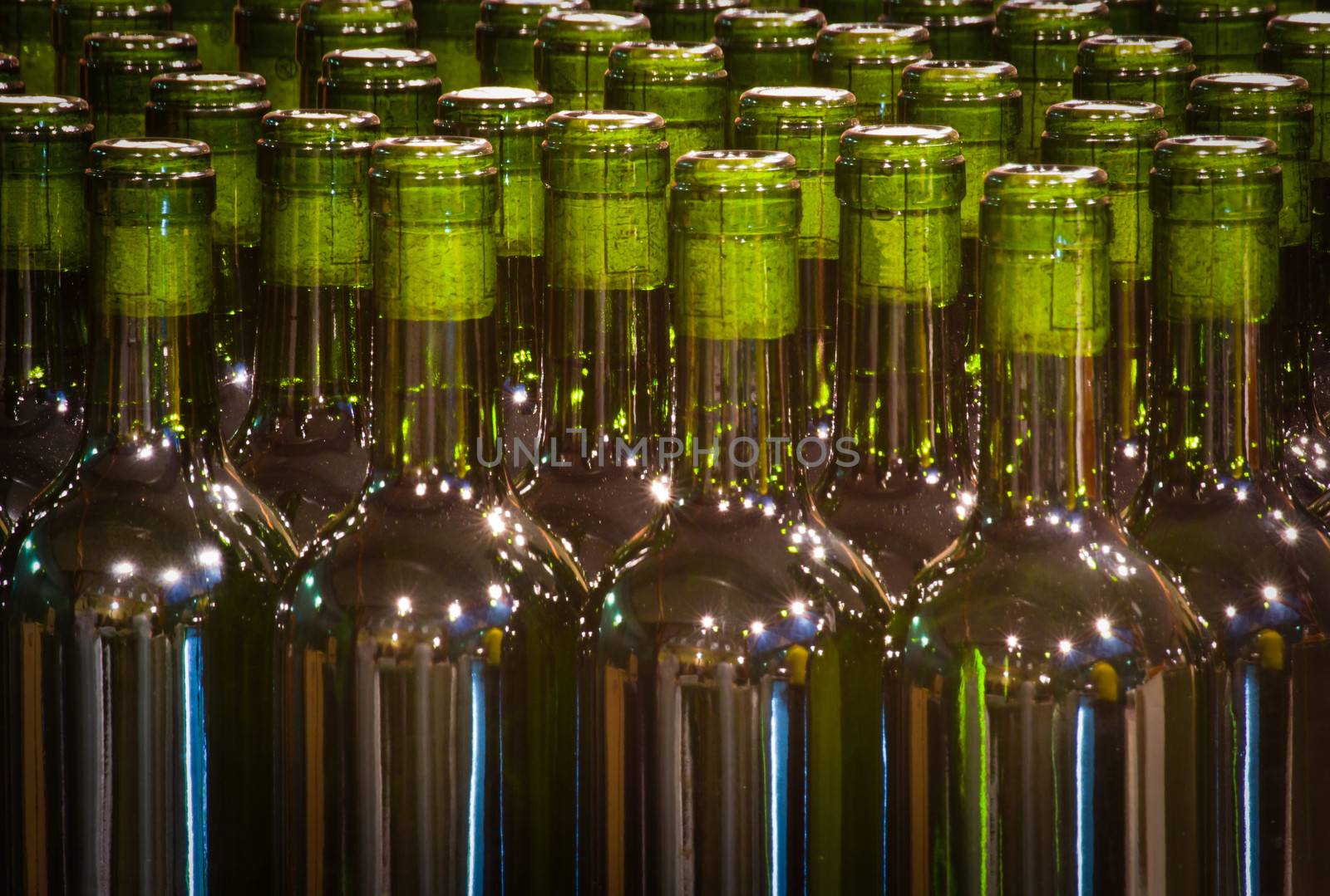 green glass bottles with cork in a wine factory