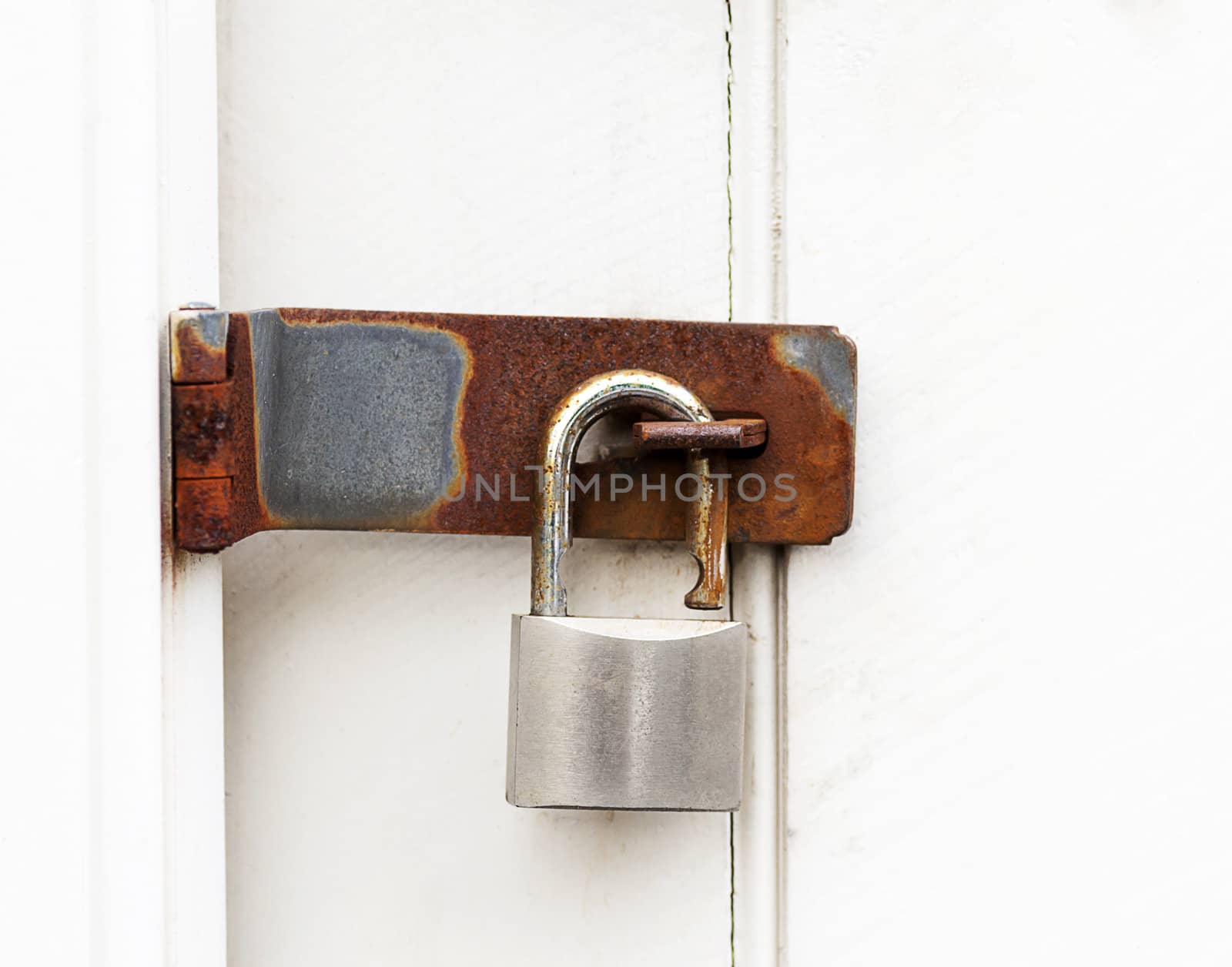 close up of a rusty padlock on a wooden door