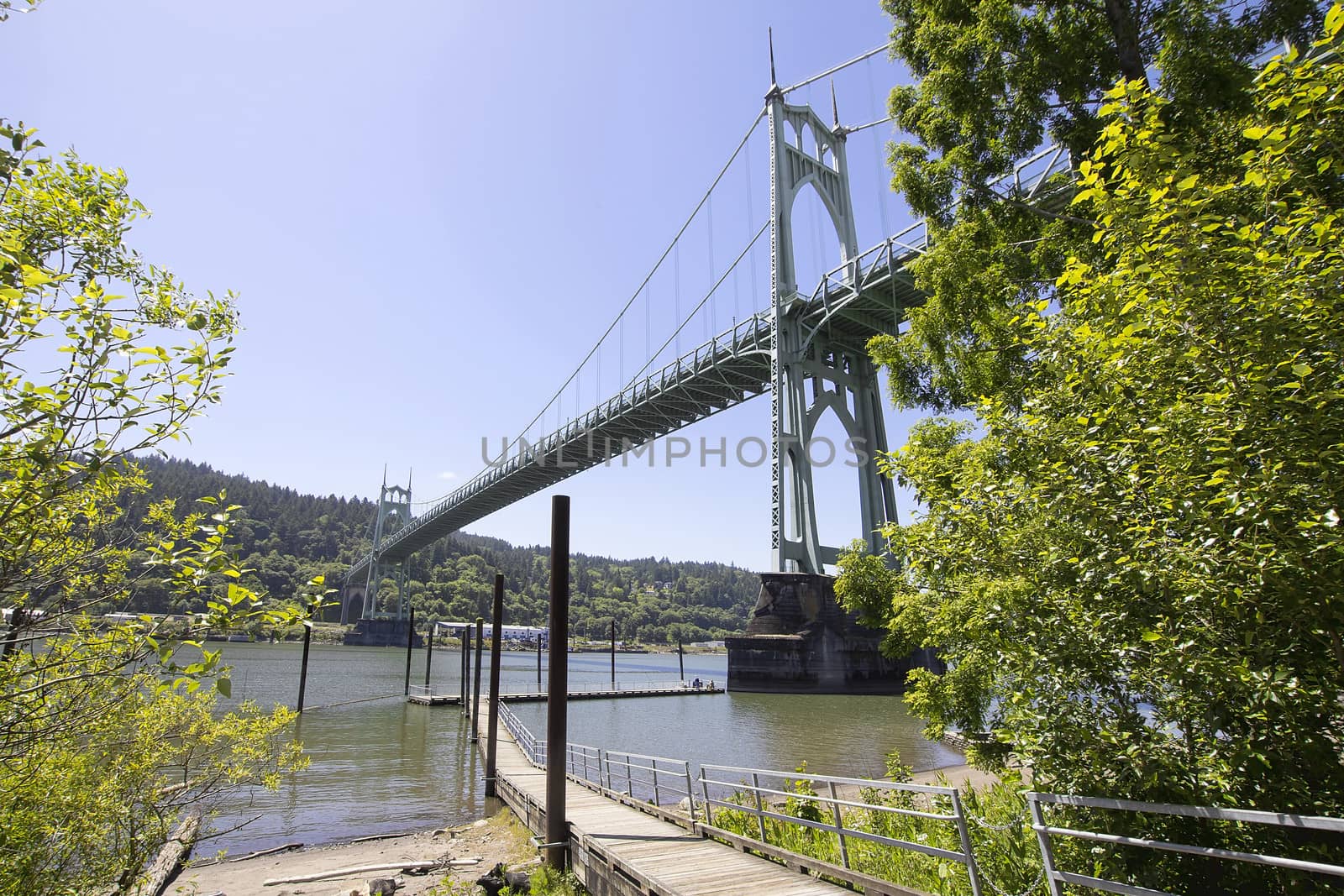 St Johns Bridge with Fishing Boat Dock on Willamette River on a Clear Blue Sky Day