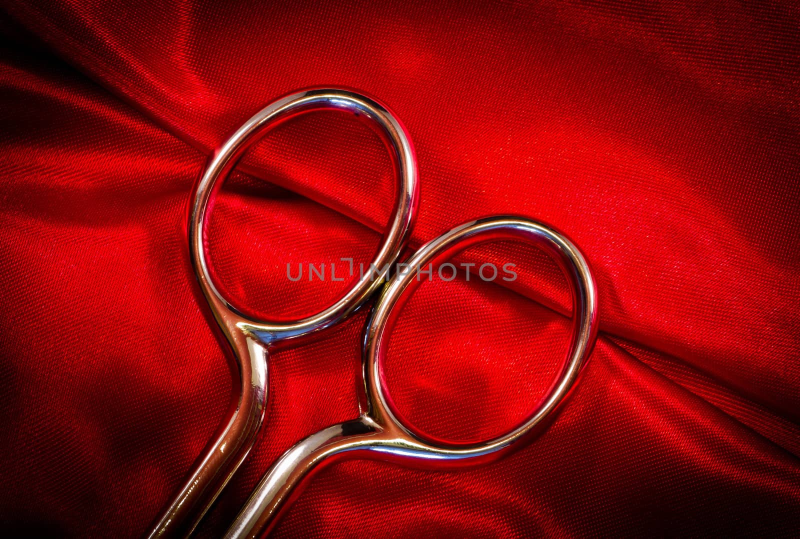 steel scissors on red fabric