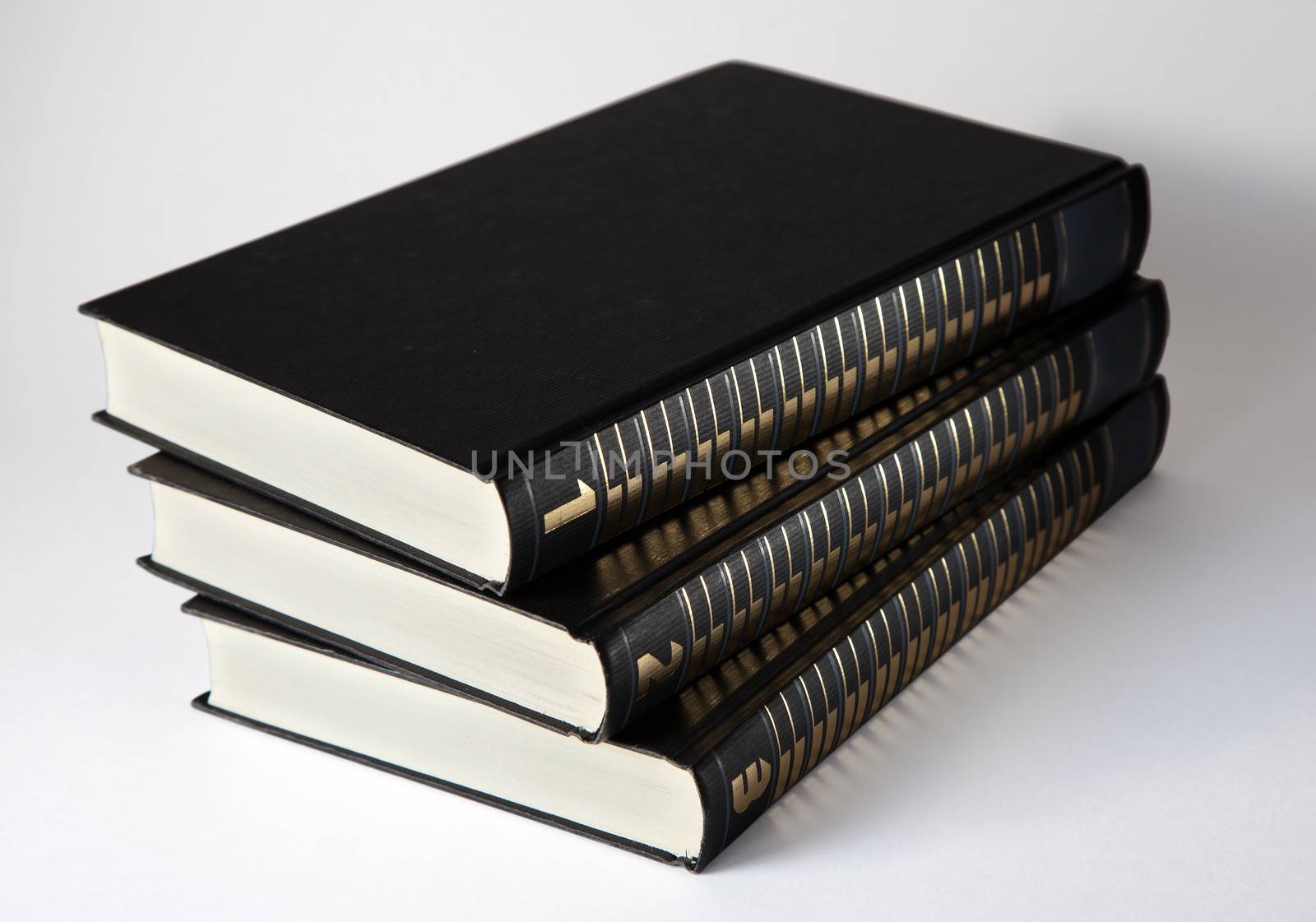 three books in black covers on light background