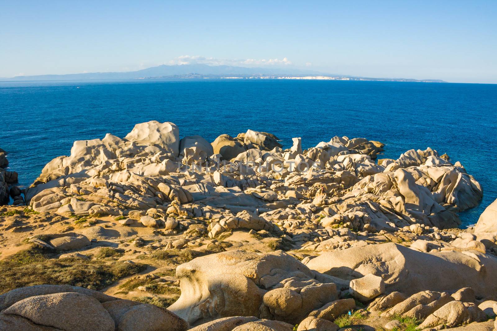 bizarre rocks at Capo Testa, Sardinia, Italy, in the background Corsica, France