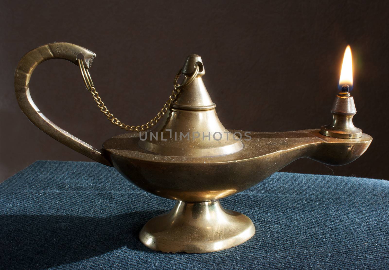 old brass magic lamp burning on the table