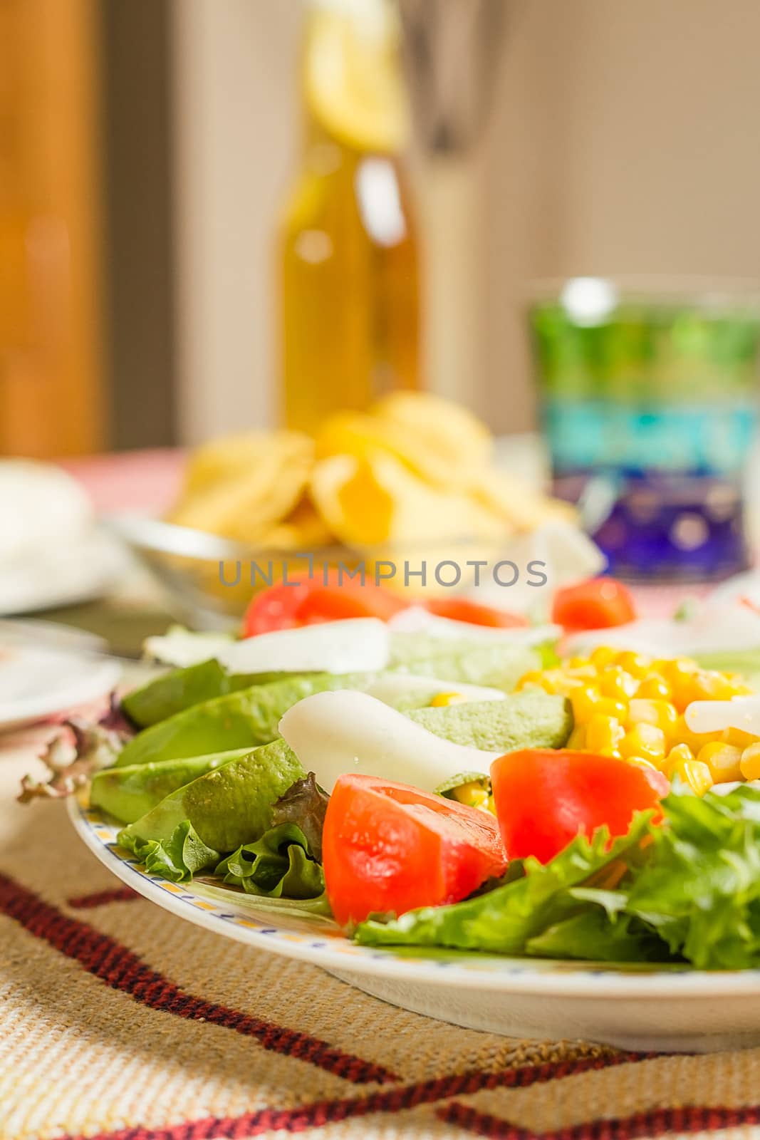 Closeup of traditional mexican food in a table, with a plate of fresh salad and a  bowl of nachos