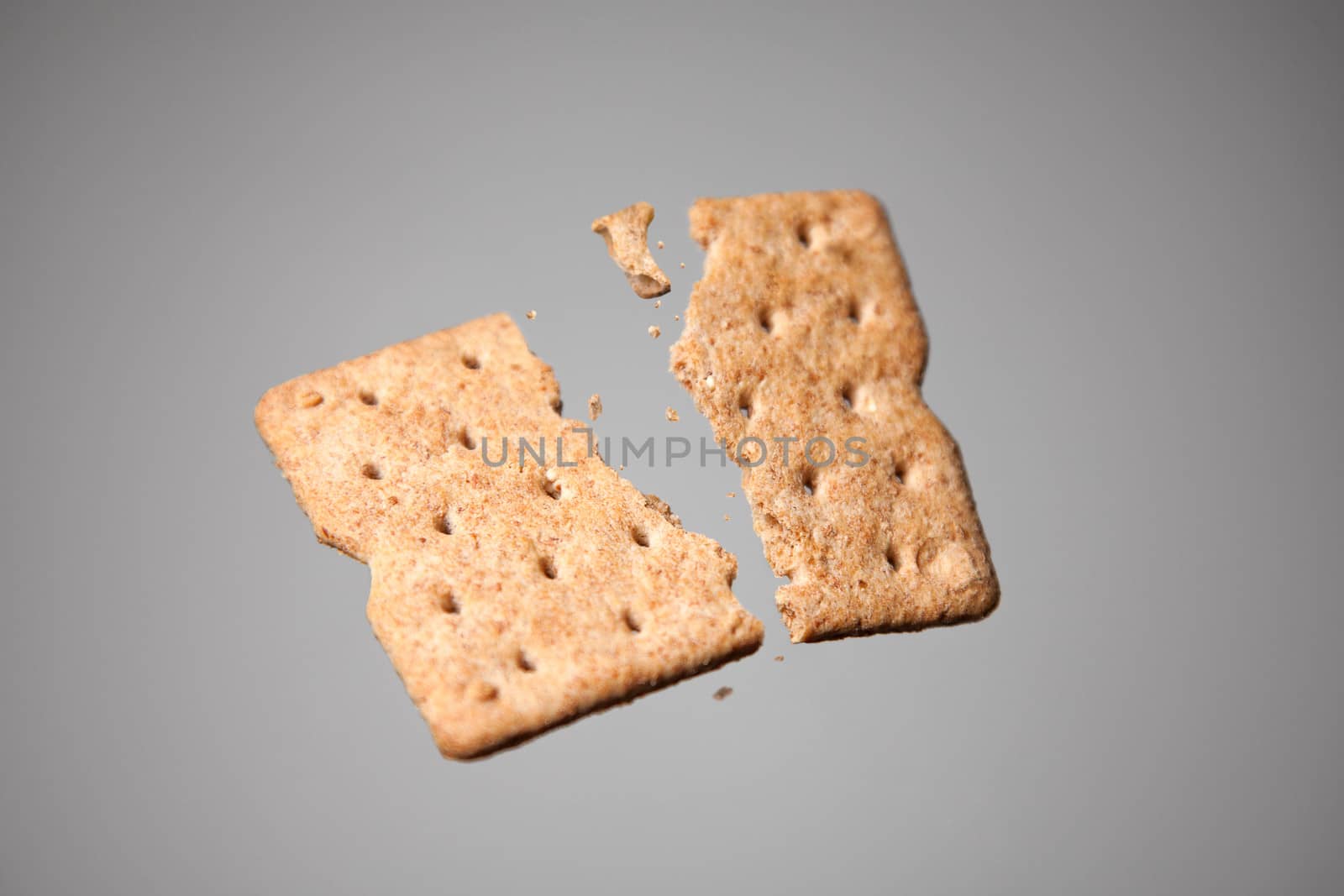Cracker in motion, studio shot on gray background 