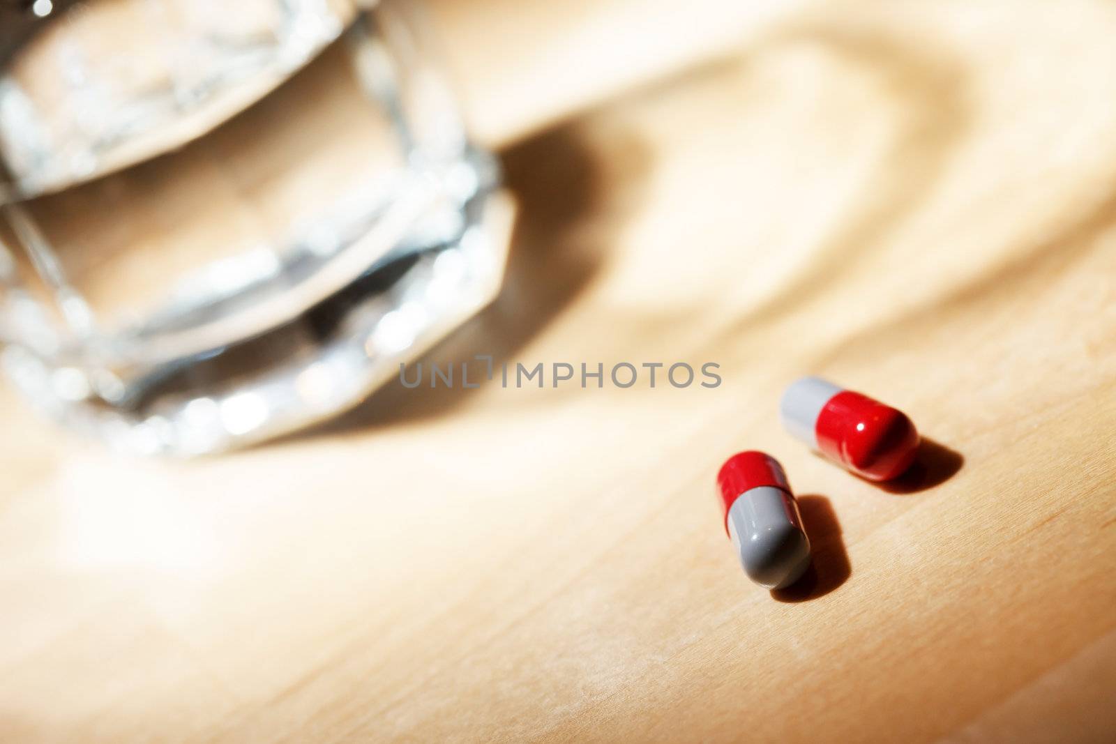 Glass of water and pills by shebeko