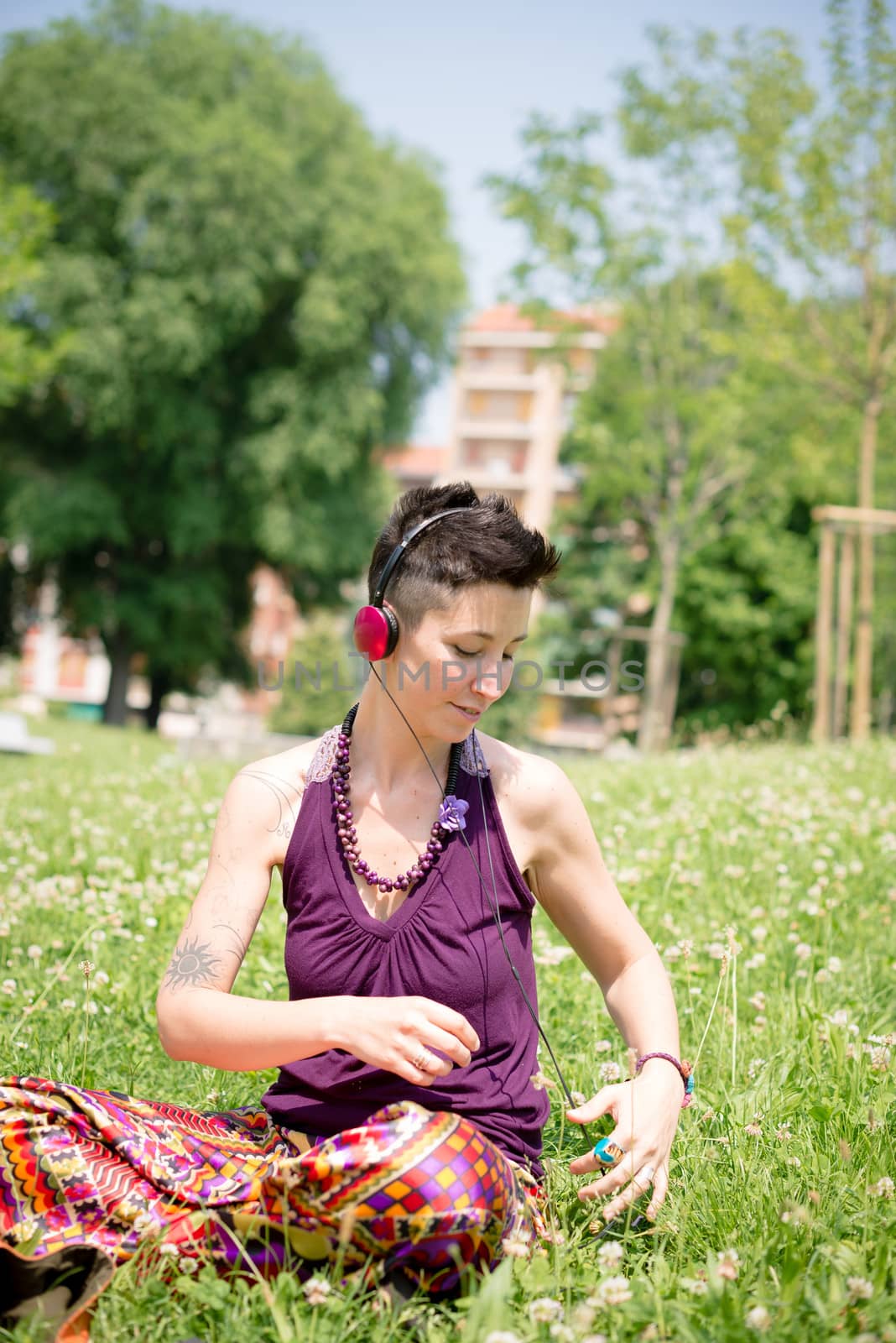 beautiful hipster short hair woman listening music in the park in the city