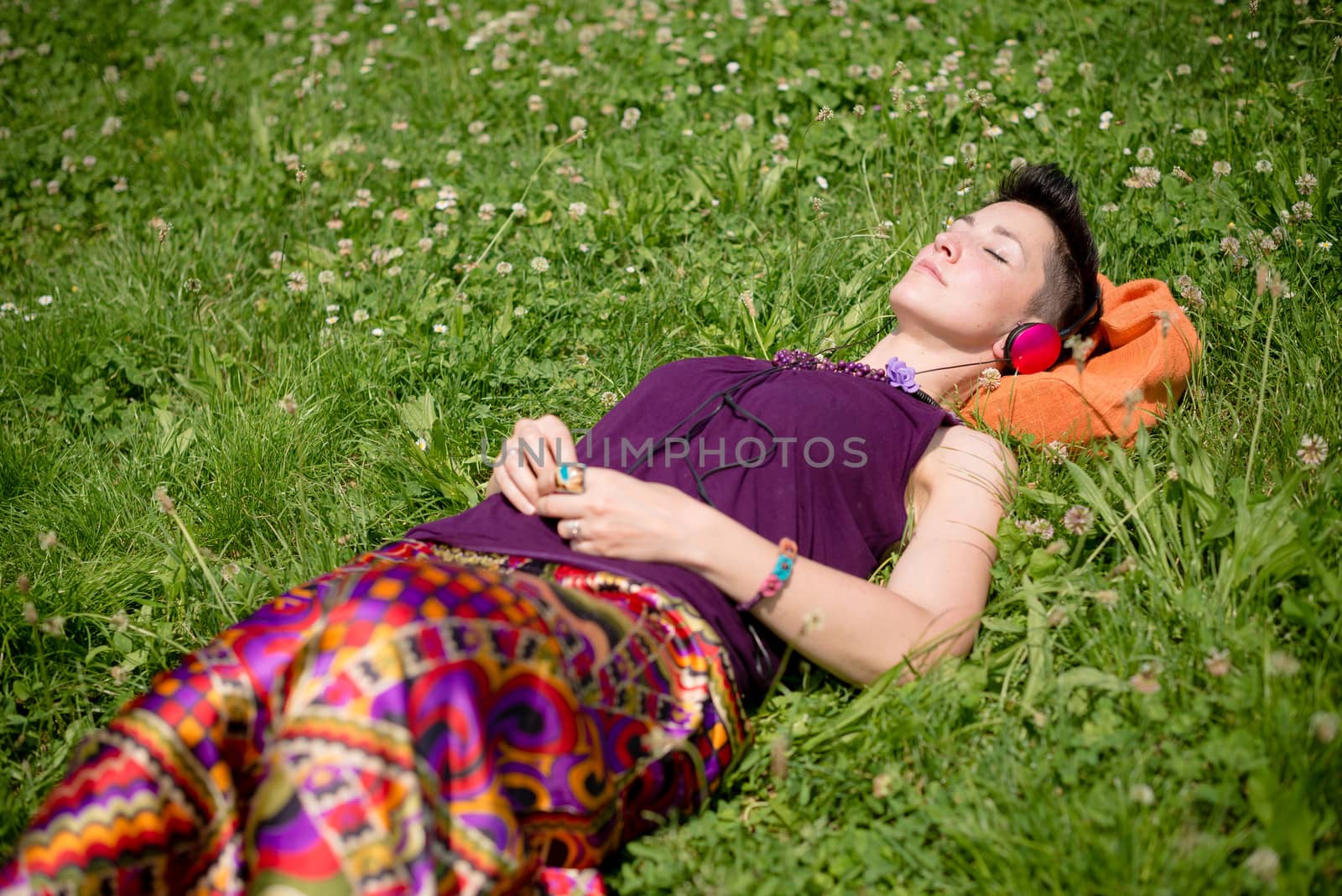 beautiful hipster short hair woman listening music in the park in the city