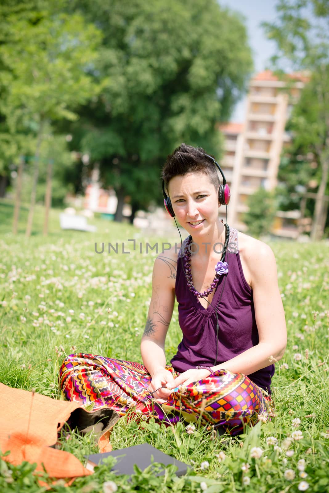 beautiful hipster short hair woman listening music in the park in the city