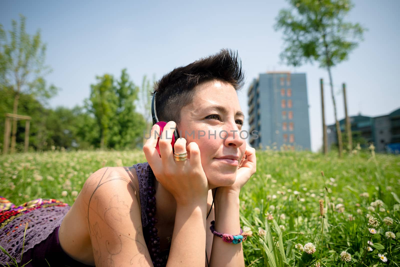 beautiful hipster short hair woman listening music in the park in the city