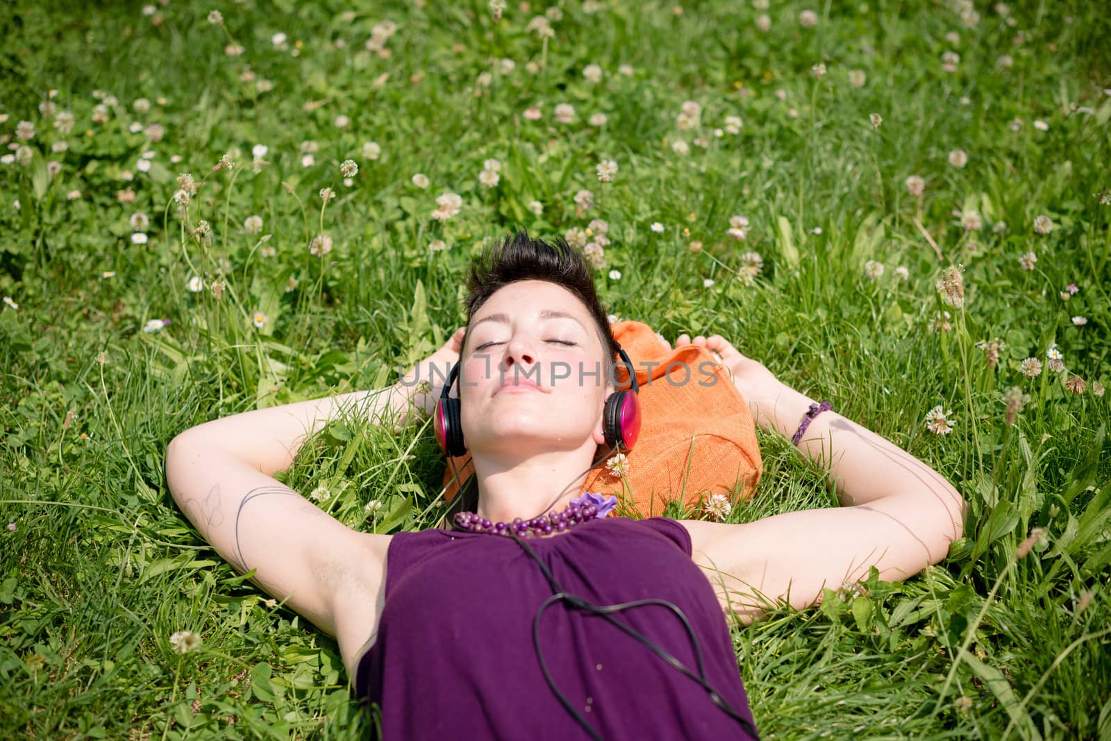 beautiful hipster short hair woman listening music in the park in the city