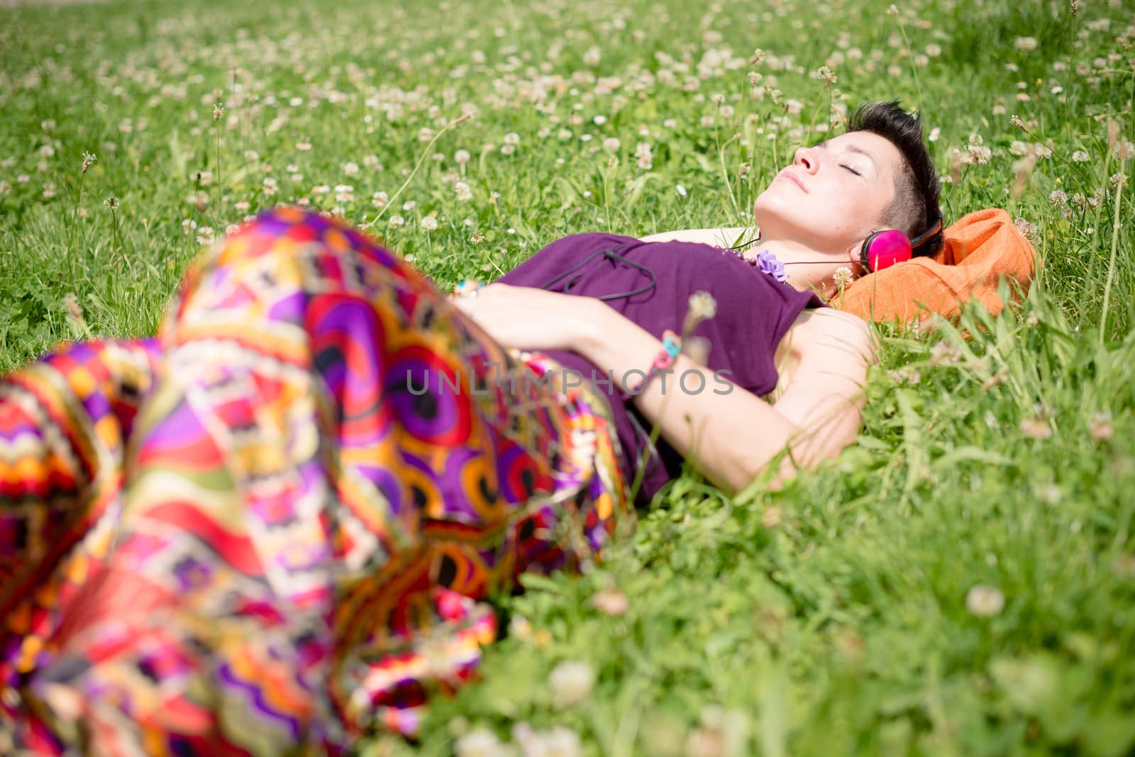 beautiful hipster short hair woman listening music in the park in the city