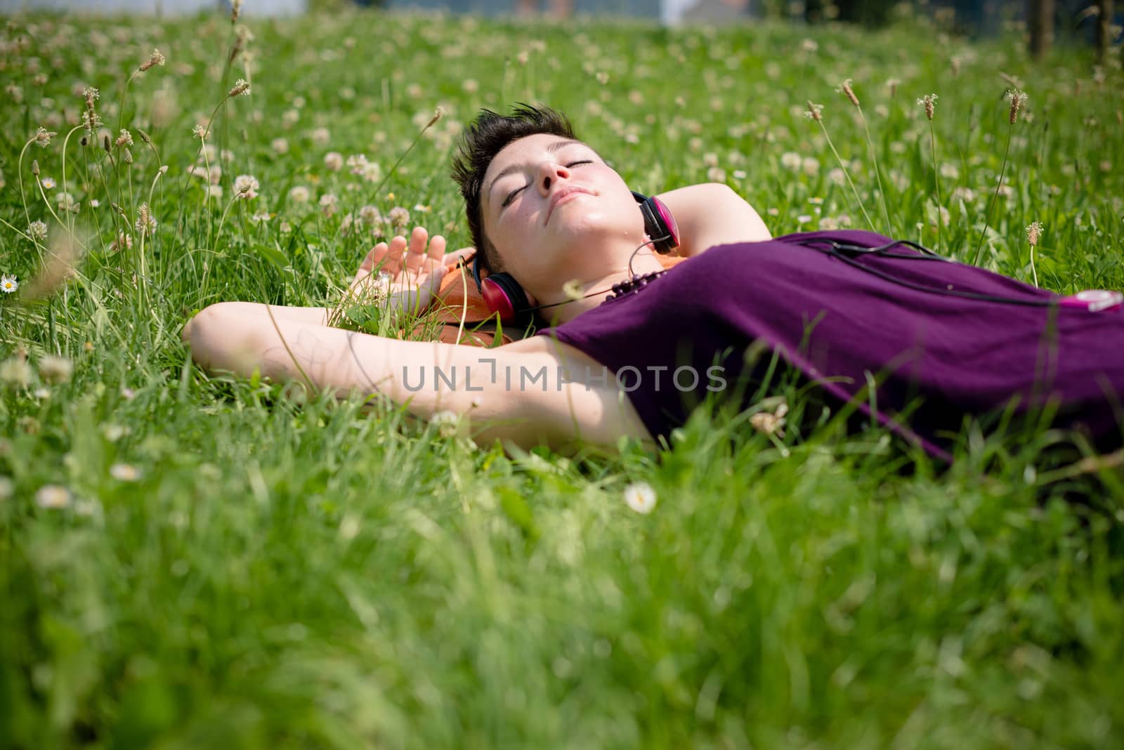 beautiful hipster short hair woman listening music in the park in the city