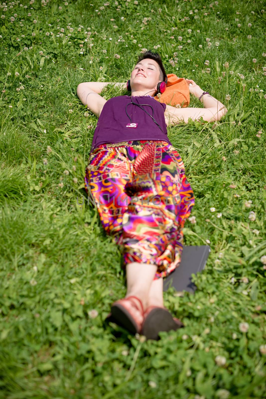 beautiful hipster short hair woman listening music in the park in the city