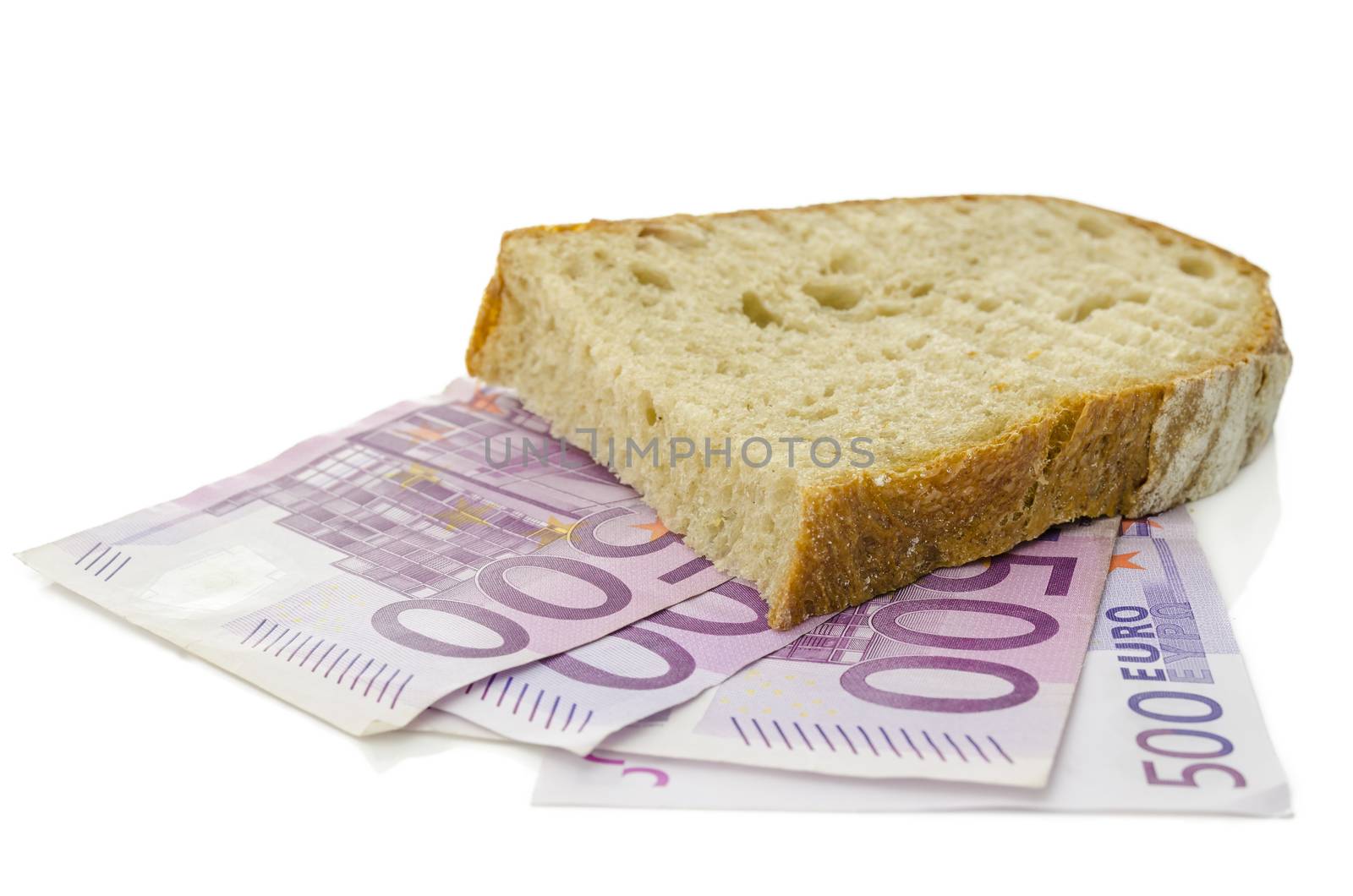 Piece of bread on Euro banknotes. Isolated over white background.