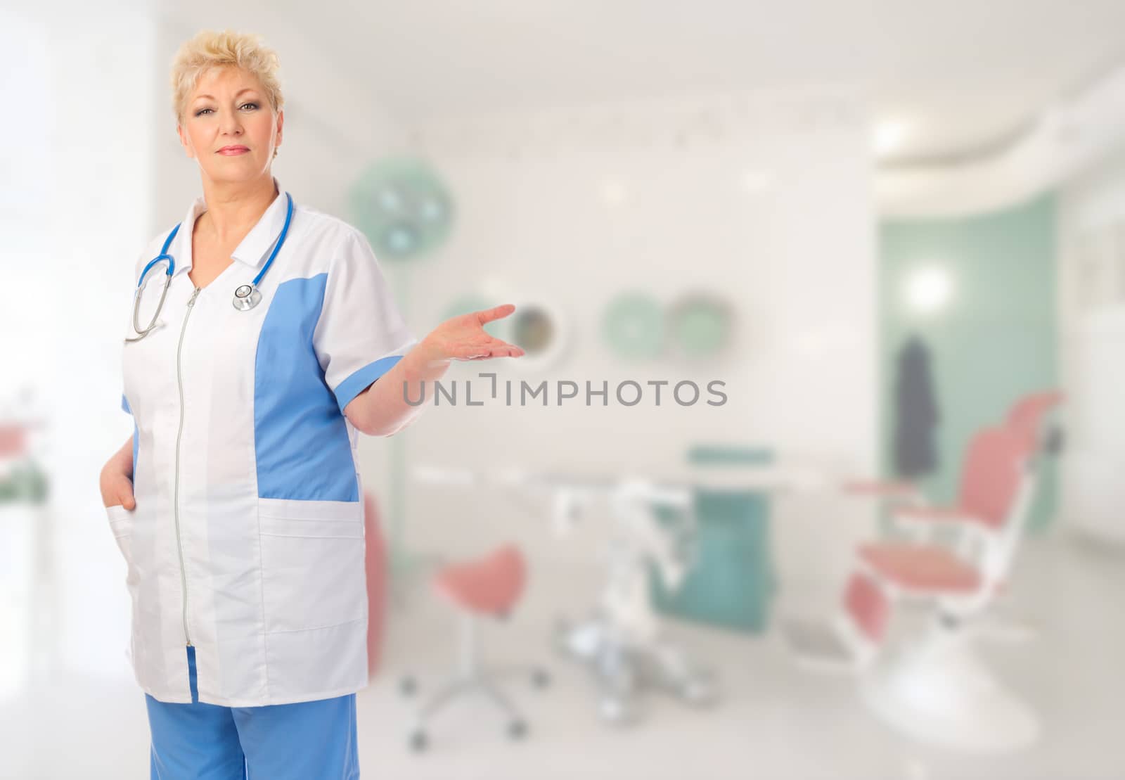 Mature doctor shows welcome gesture at medical office