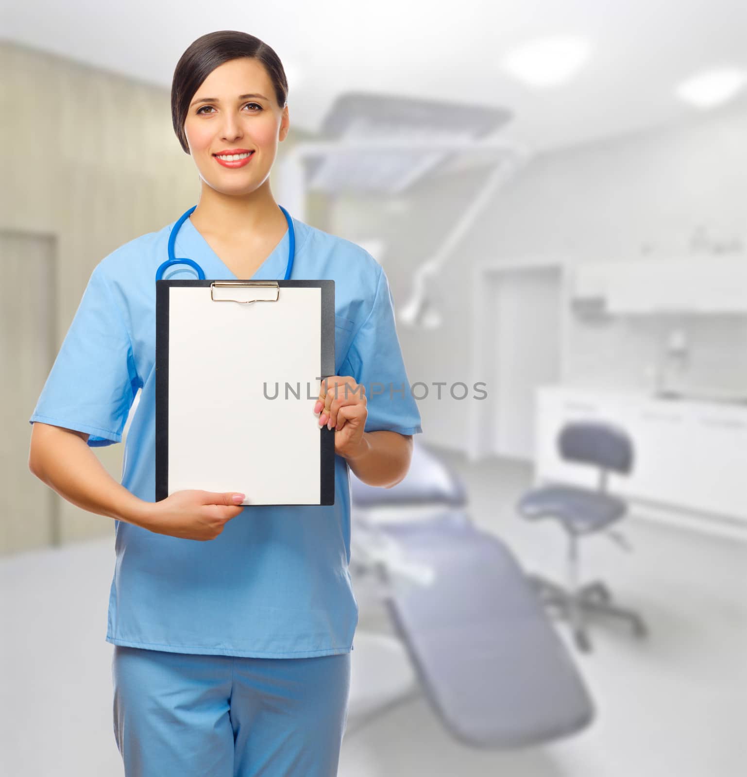 Young doctor with clipboard at medical office