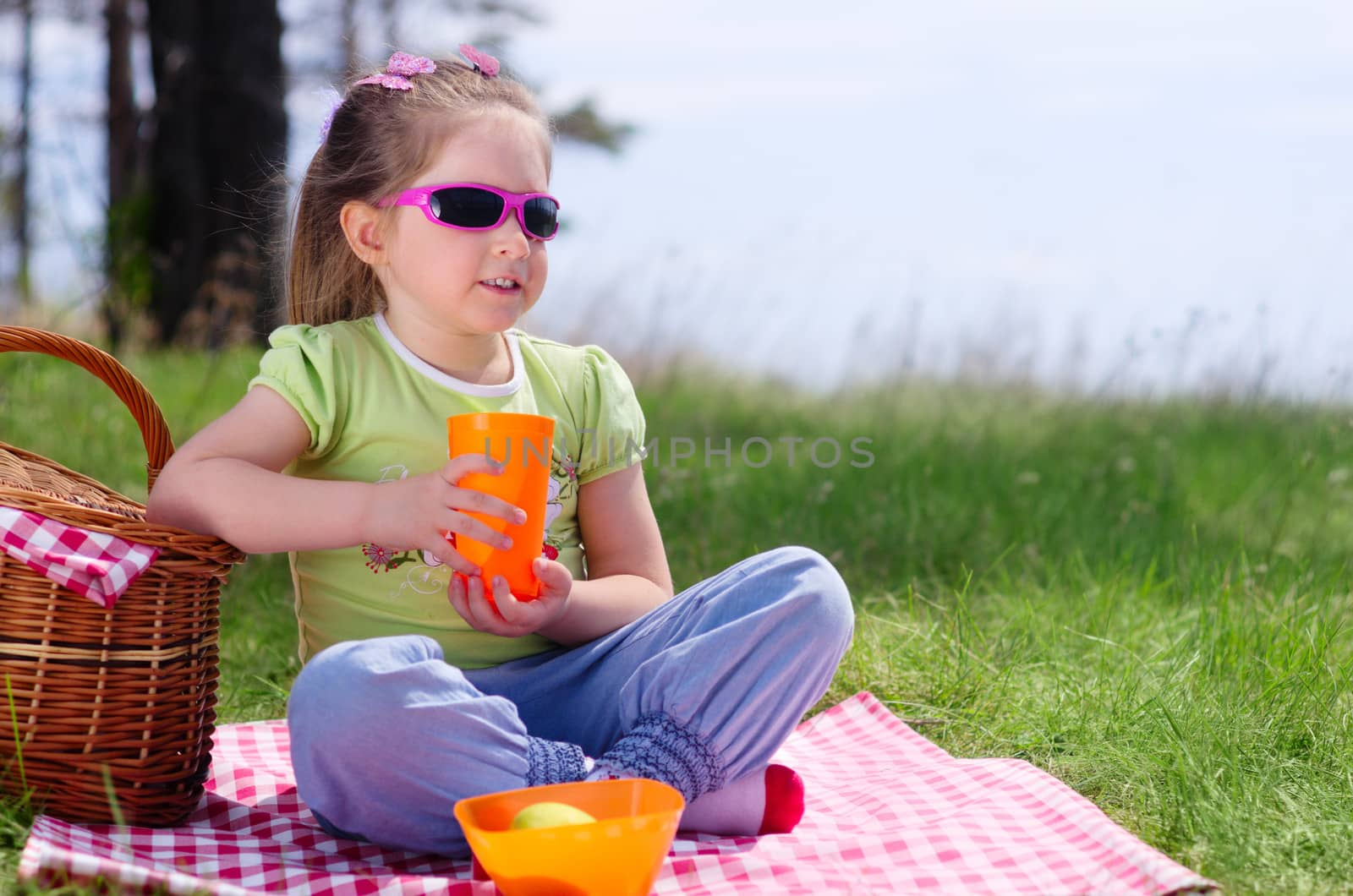Little girl with picnic basket and plastic cup by rbv