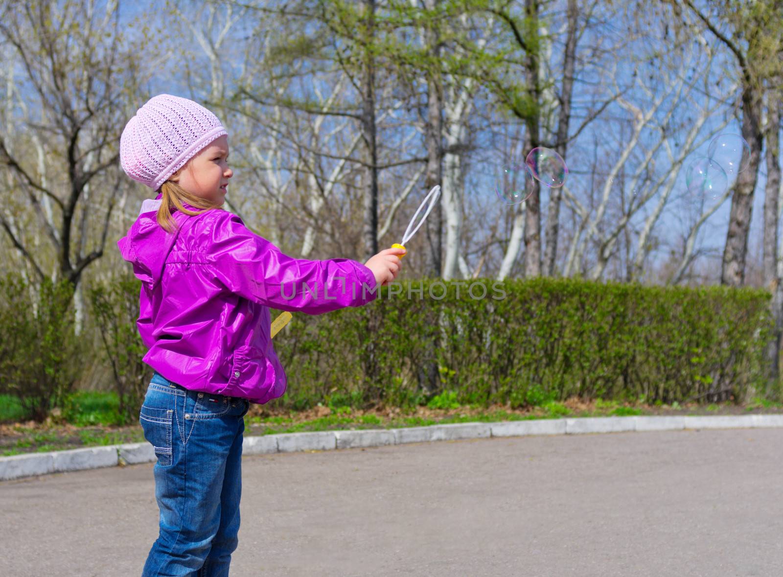 Little girl with soap bubbles at park