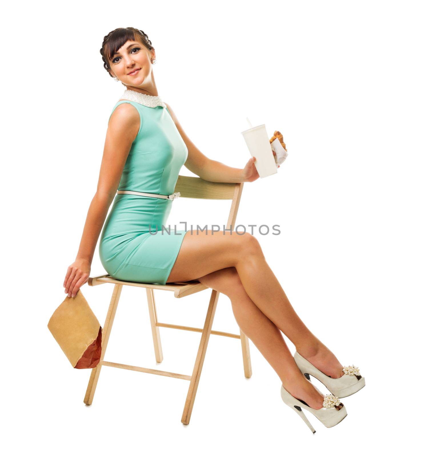 Glamorous girl in turquoise dress sitting on chair holds snacks by rbv