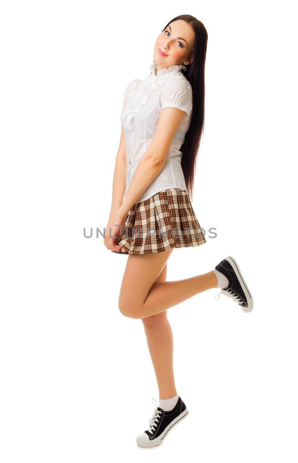 Young jumping girl in plaid skirt isolated