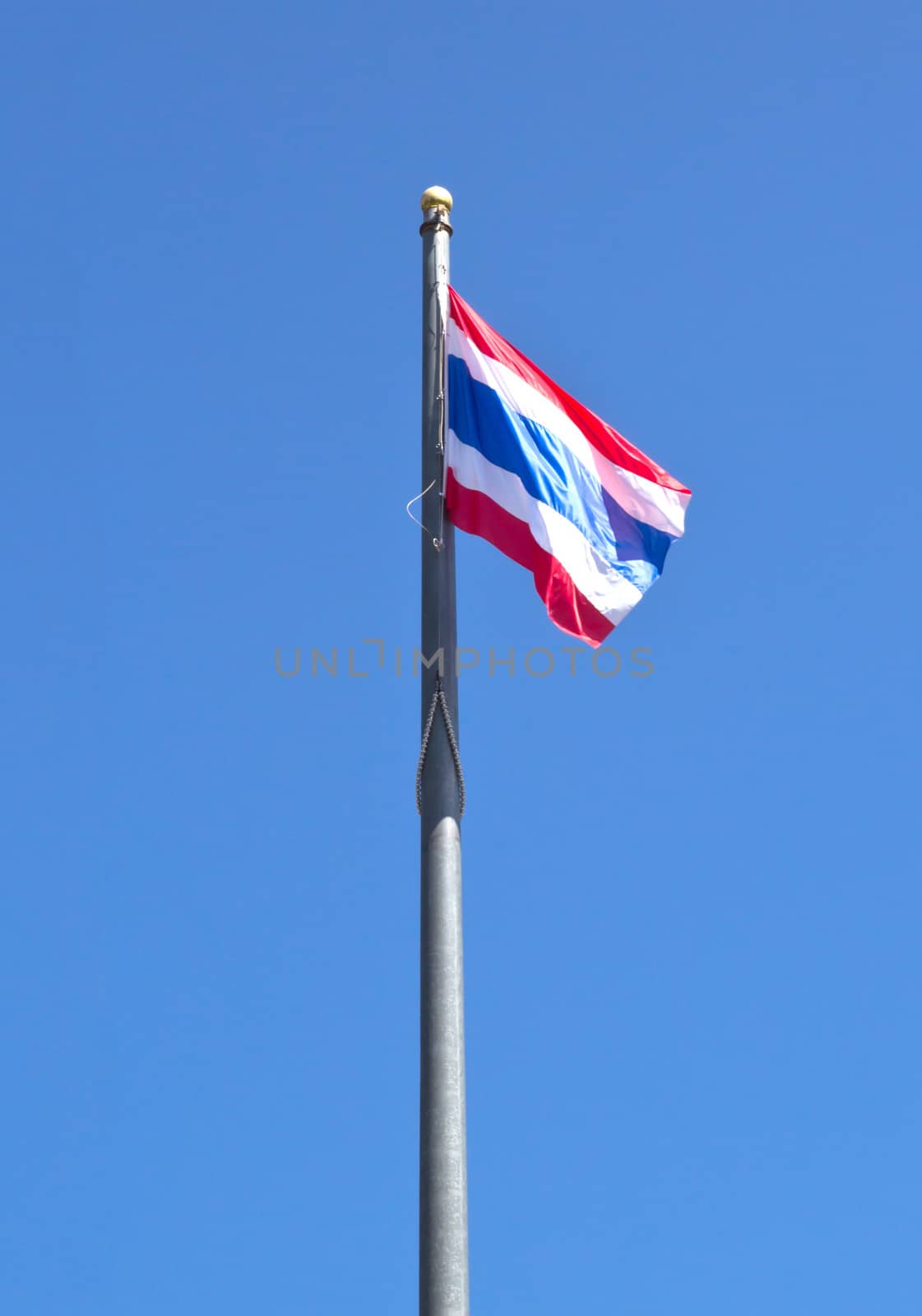 Flag of Thailand with flag pole waving in the wind blue sky