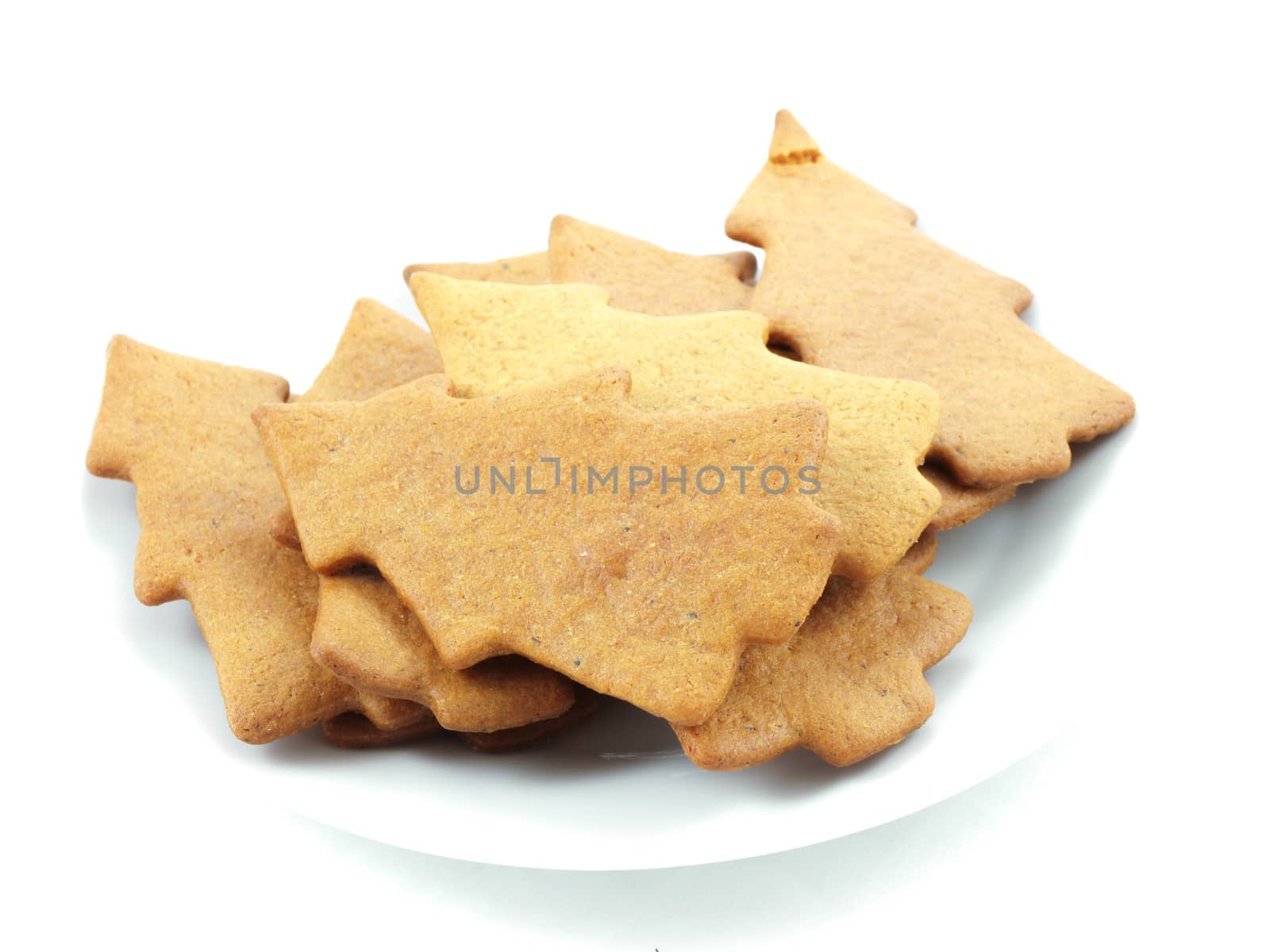 Gingerbread cookies, tree shape, on white plate towards white background