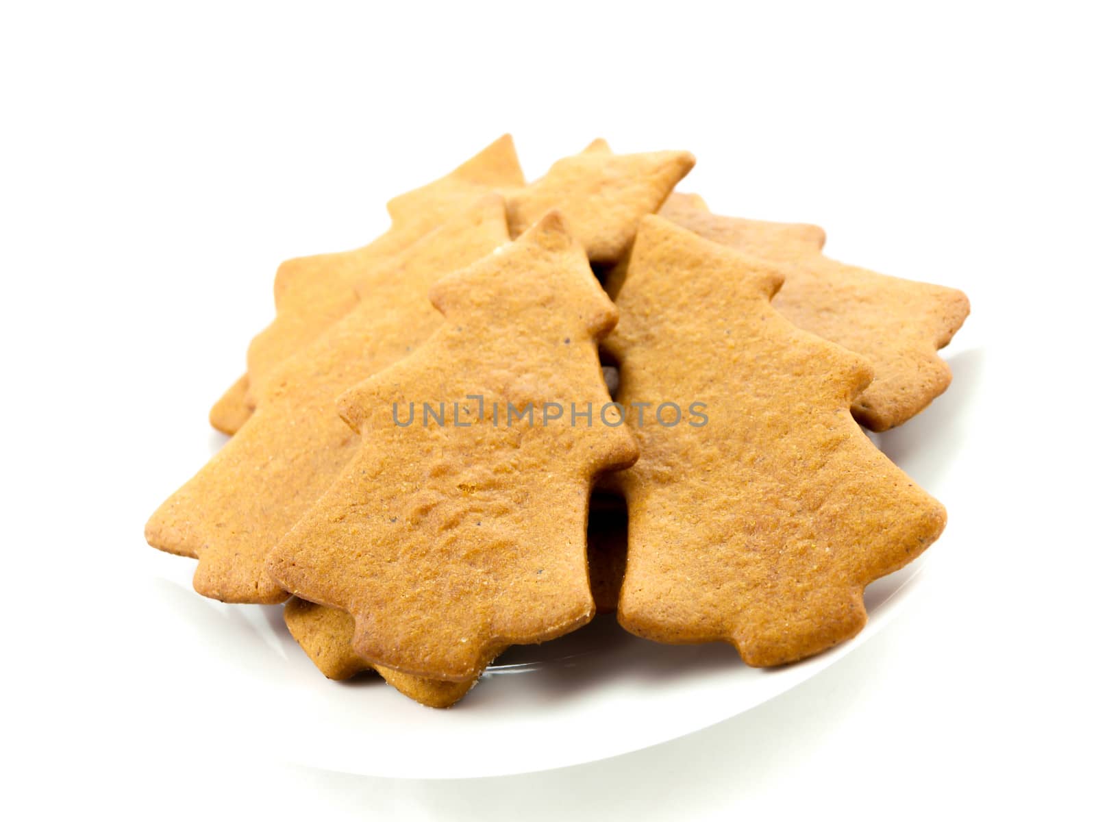 Gingerbread cookies, tree shape, on white plate towards white background