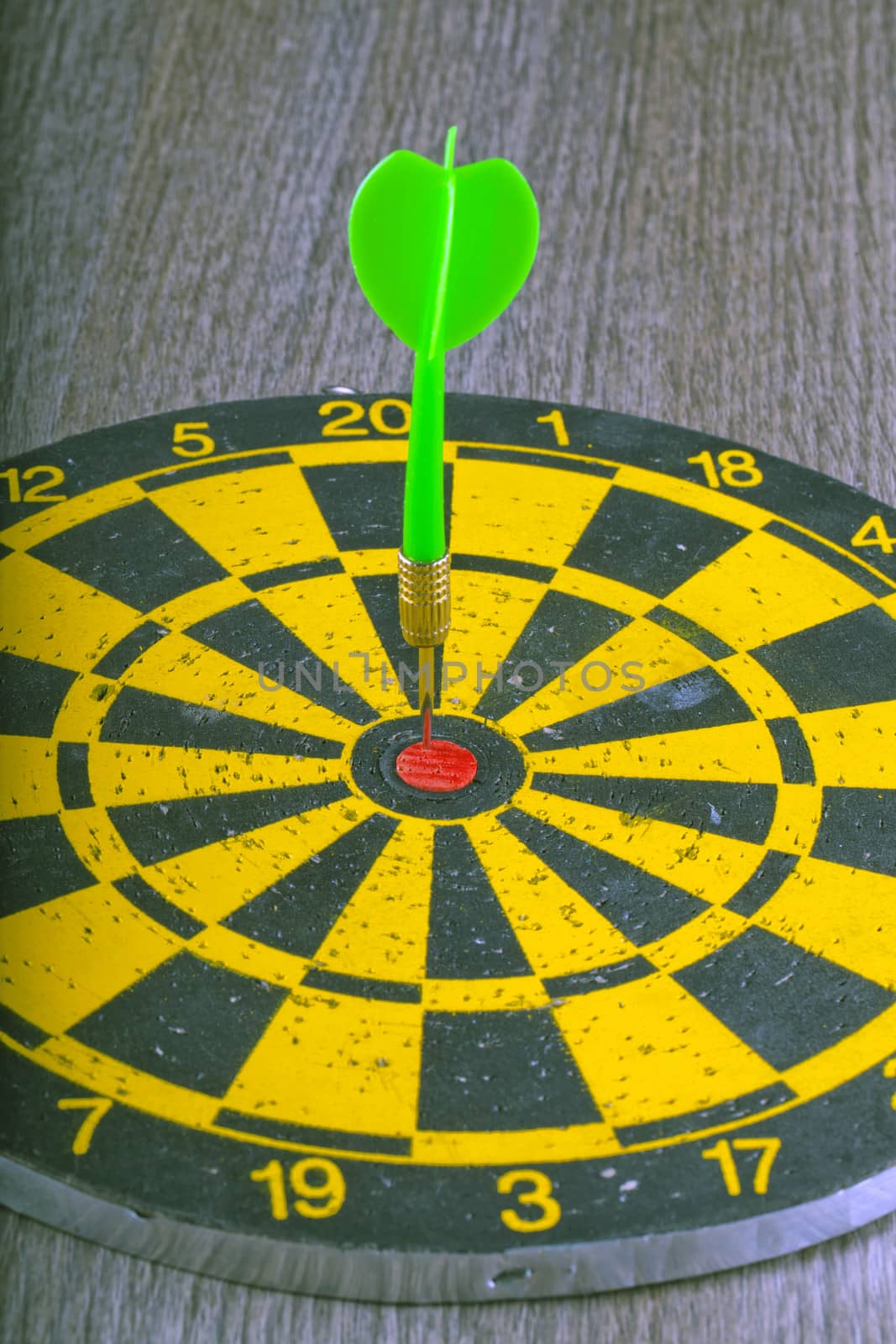 A green dart hitting the center of a target