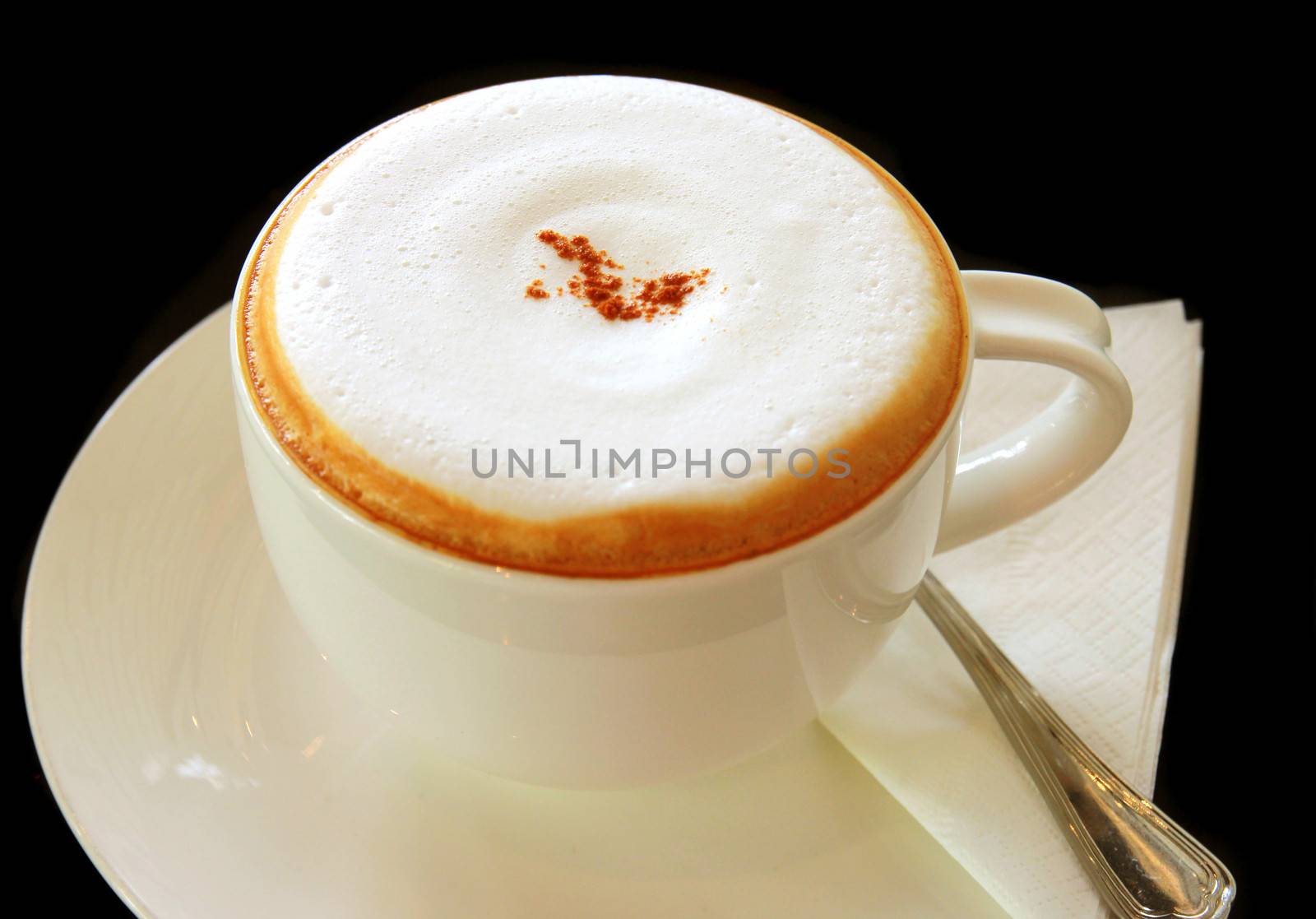 Coffee latte or cappuccino in a cup on black background