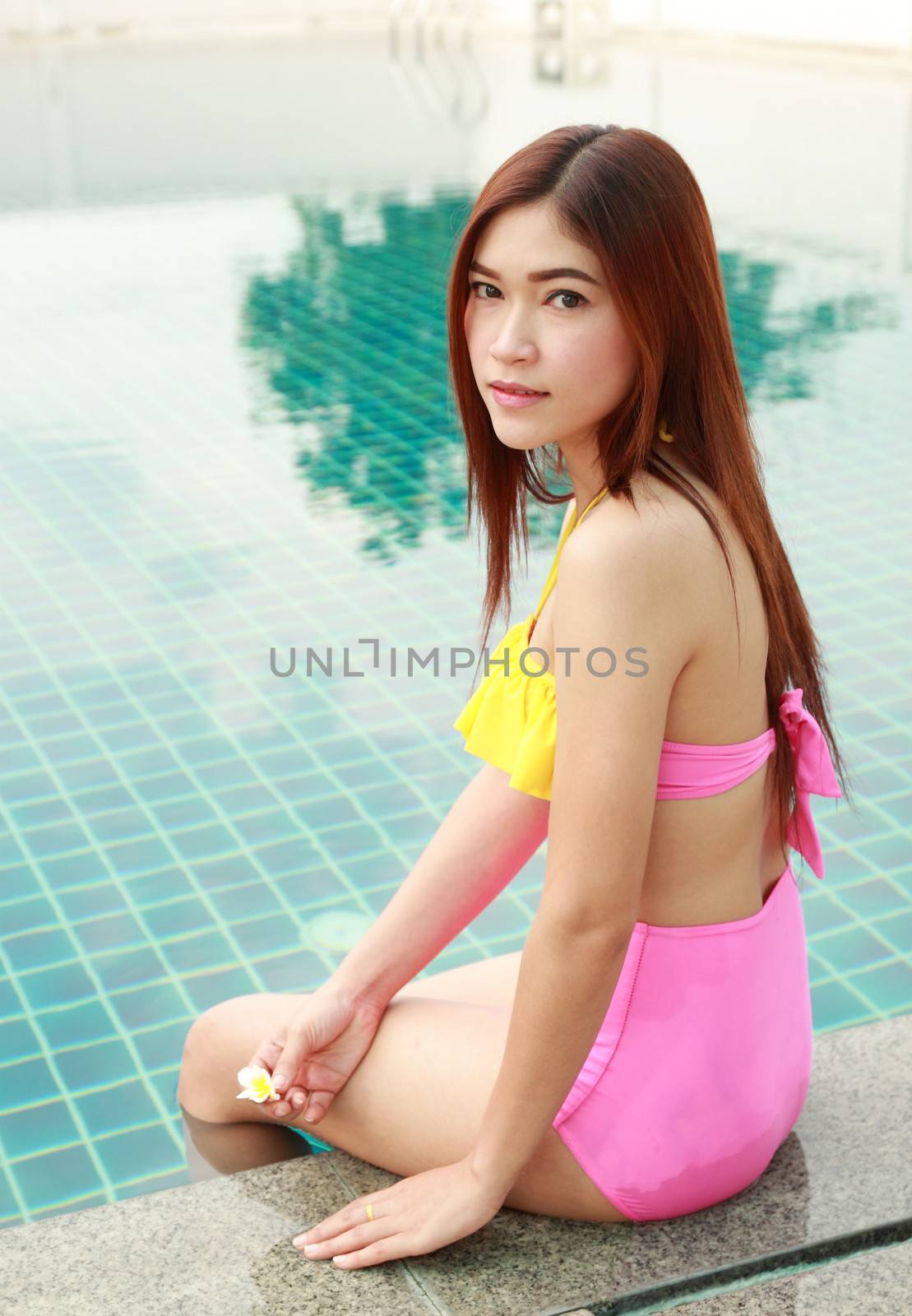 woman sitting at the edge of a swimming pool