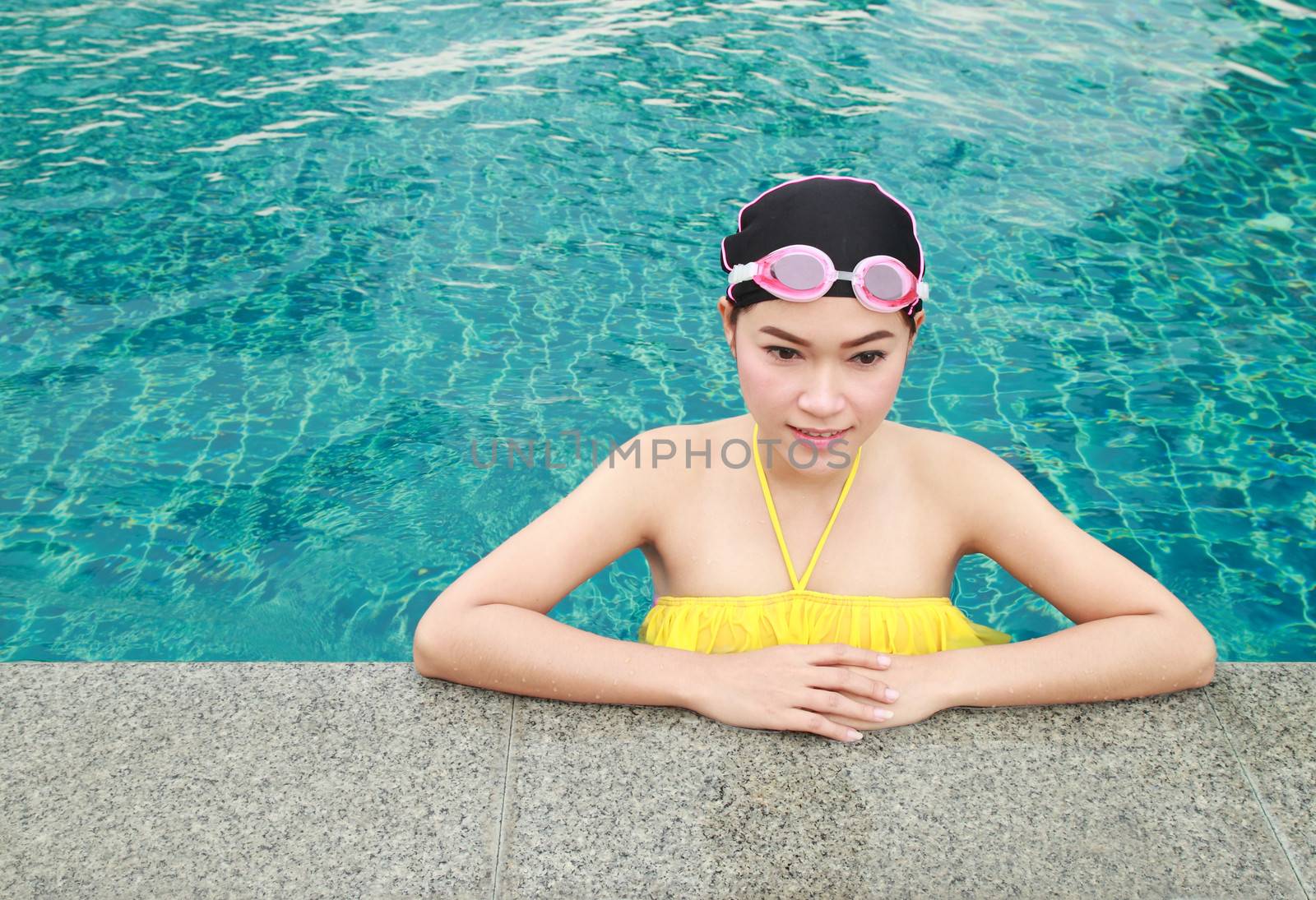 beautiful woman resting on the edge of swimming pool