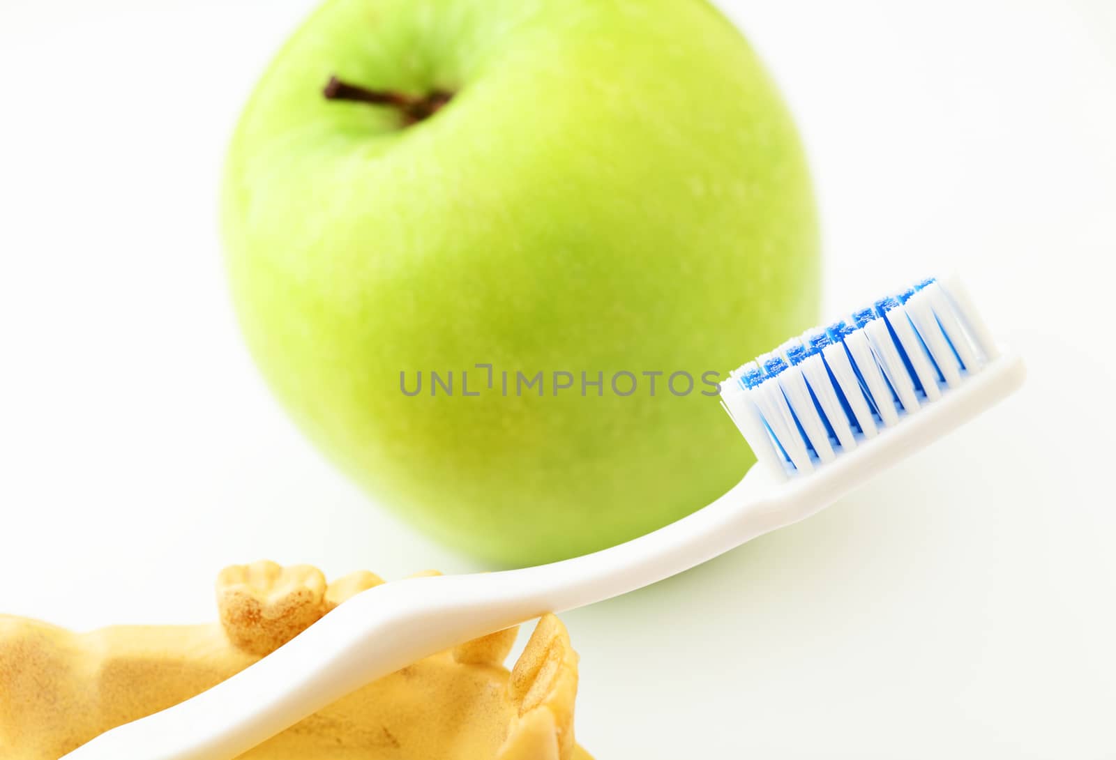 Dental health care concept, green apple and toothbrush by leungchopan