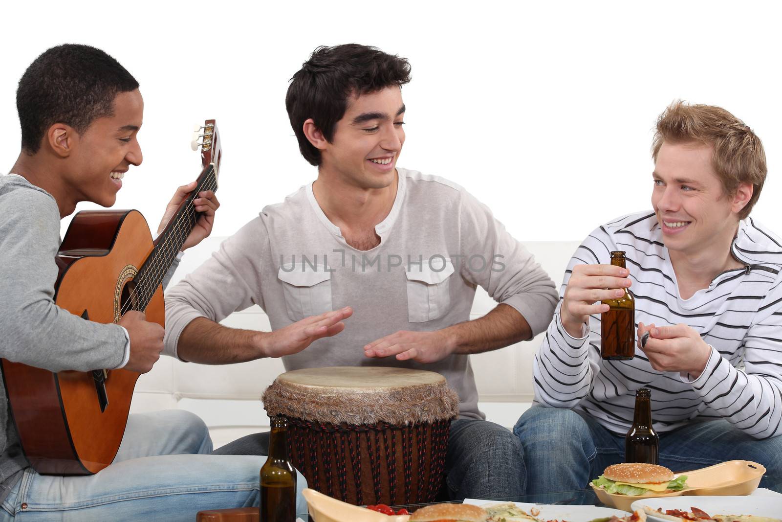 Three house-mates eating burgers and playing music