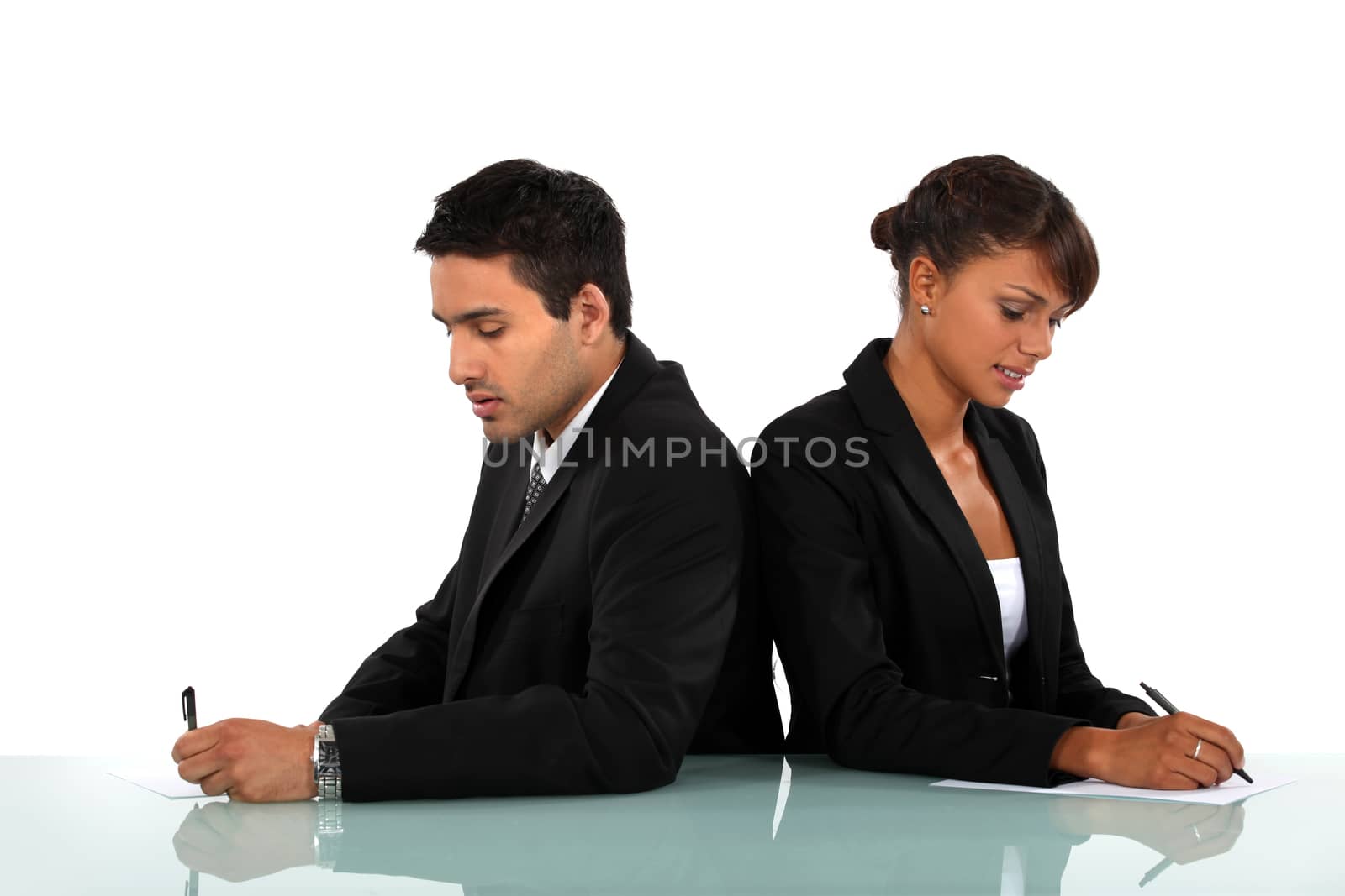 Business couple writing on forms by phovoir