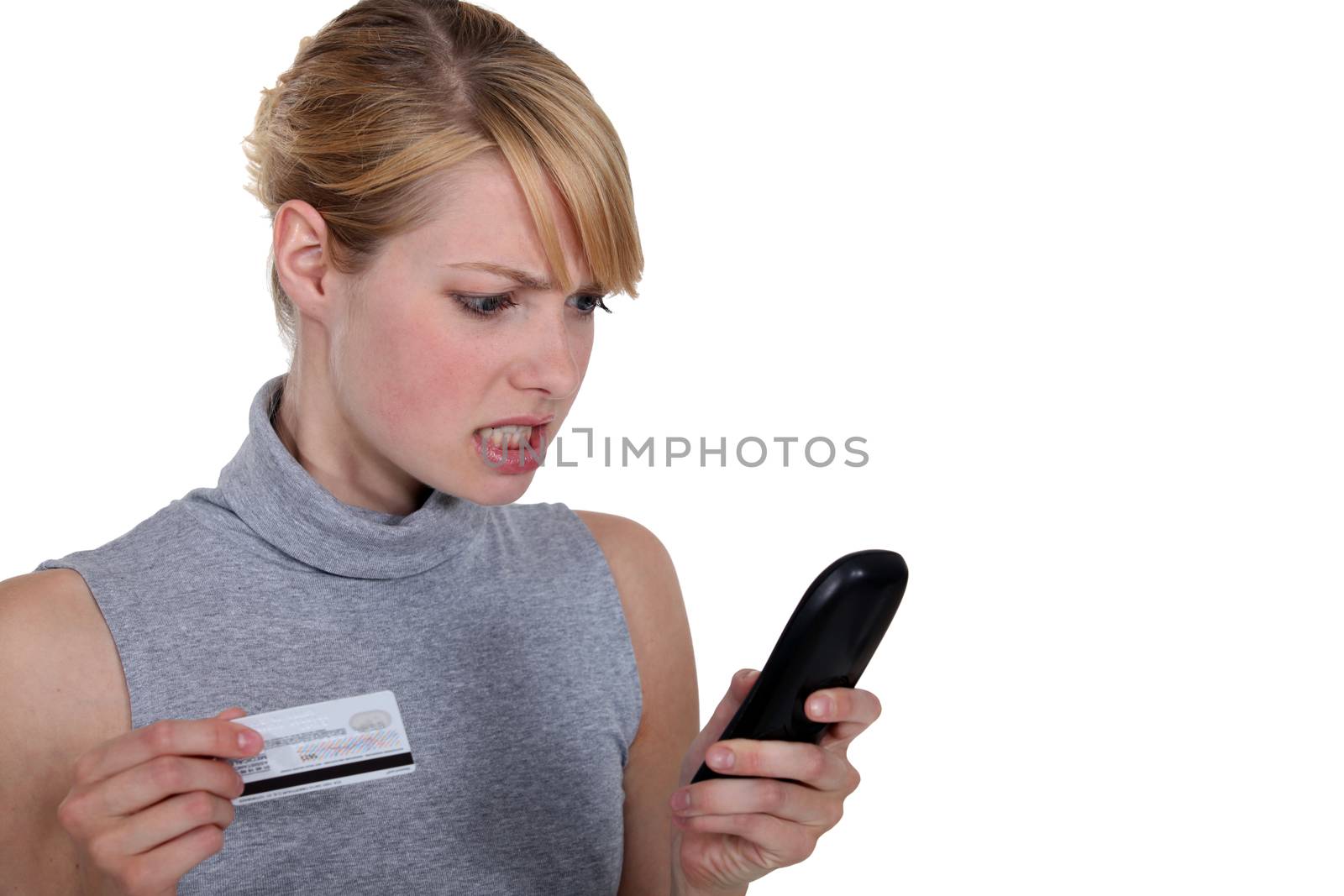 Edgy woman with credit card and telephone