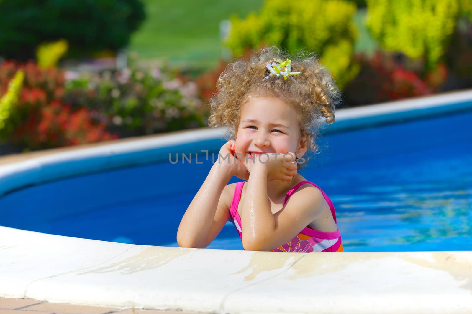 Pretty little girl in swimming pool outdoors