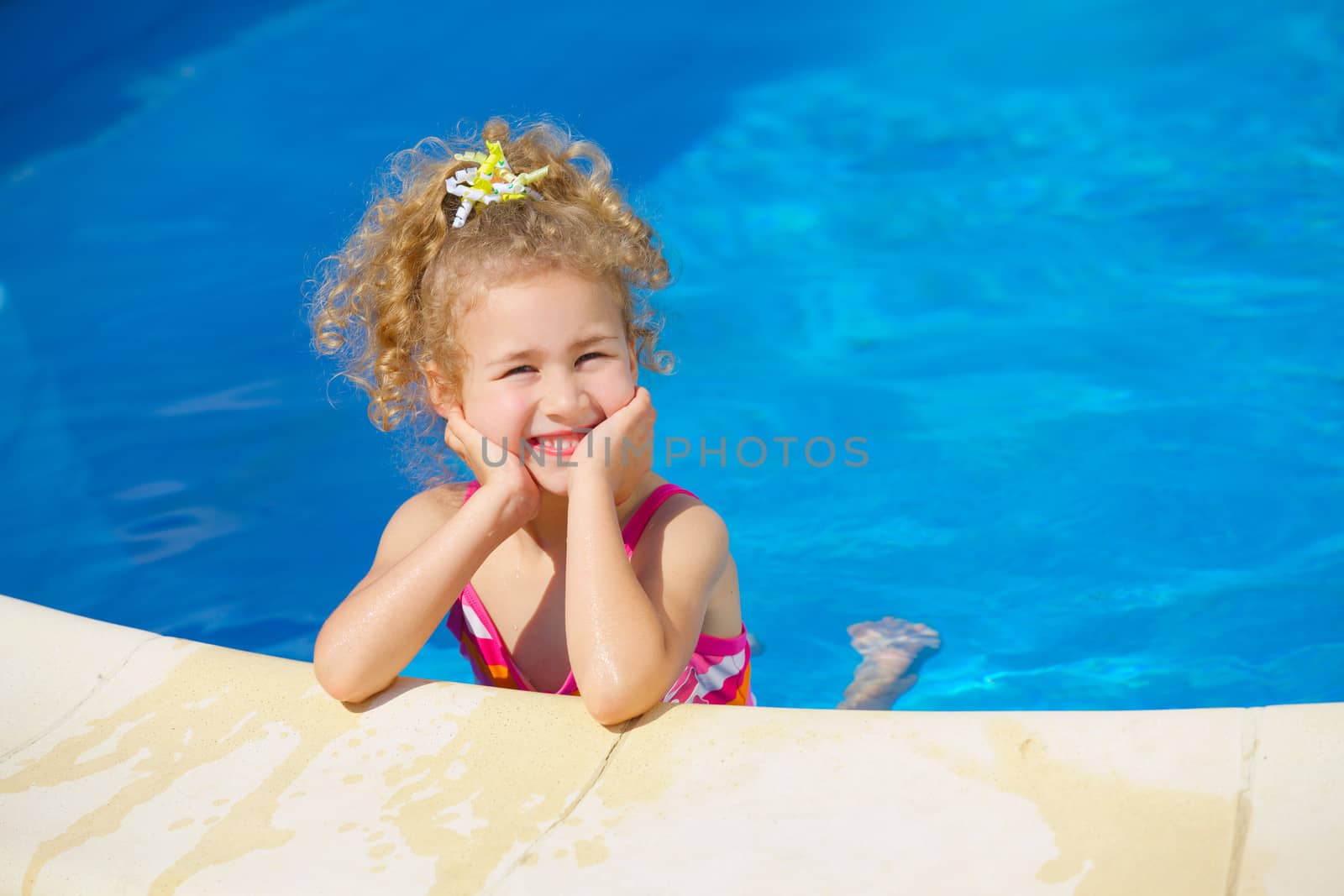 Pretty little girl in swimming pool outdoors