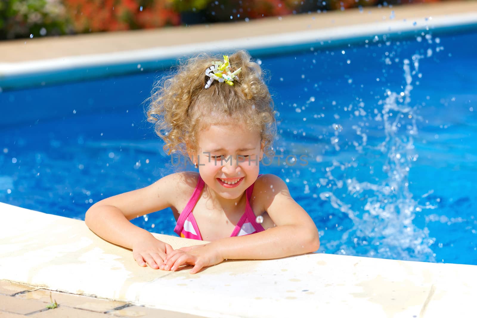 Pretty little girl in swimming pool outdoors