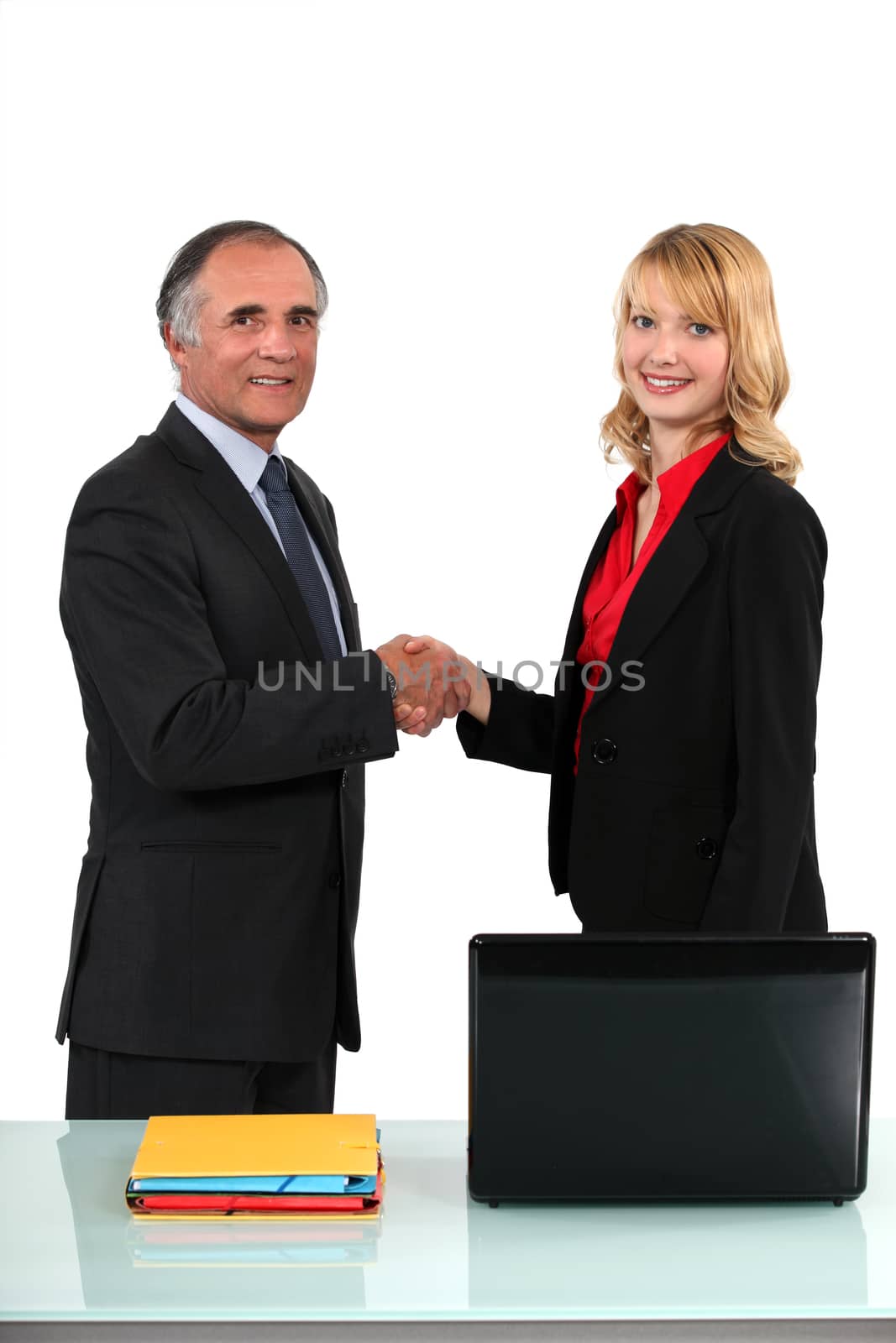 businessman and businesswoman shaking hands by phovoir