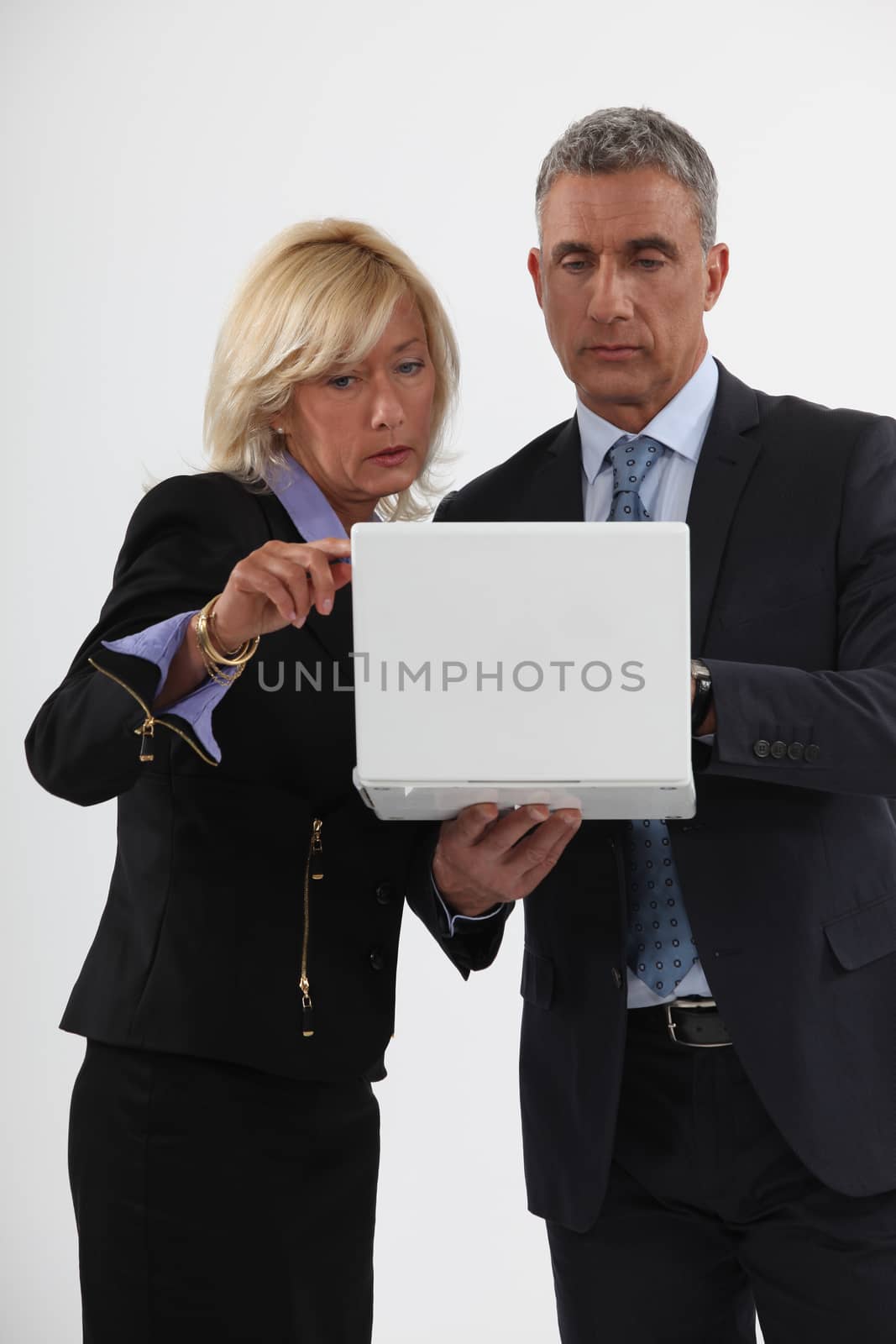 Mature businessman and businesswoman in front of computer by phovoir