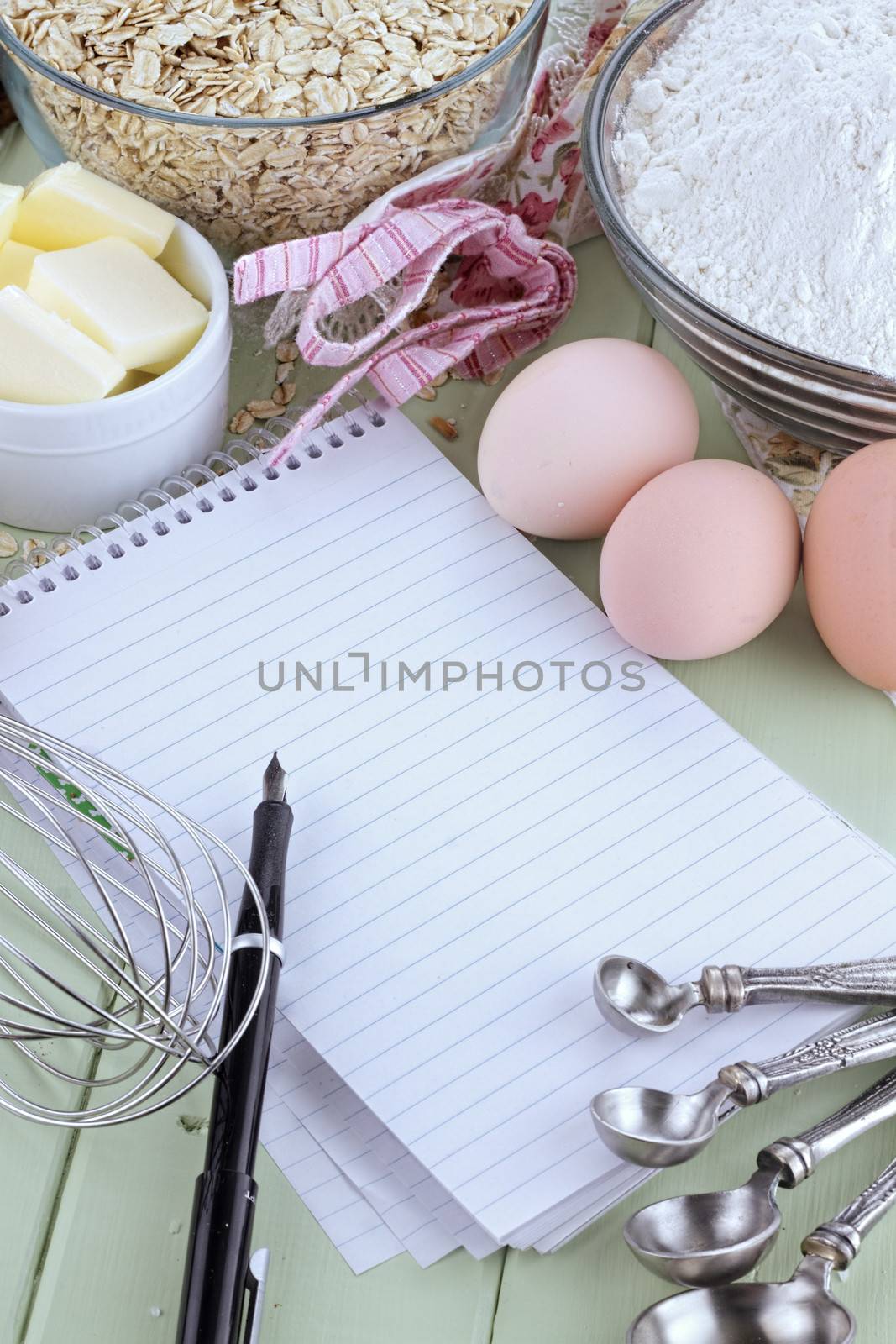 Fresh ingredients of oats, flour, butter and eggs with pen and paper. 