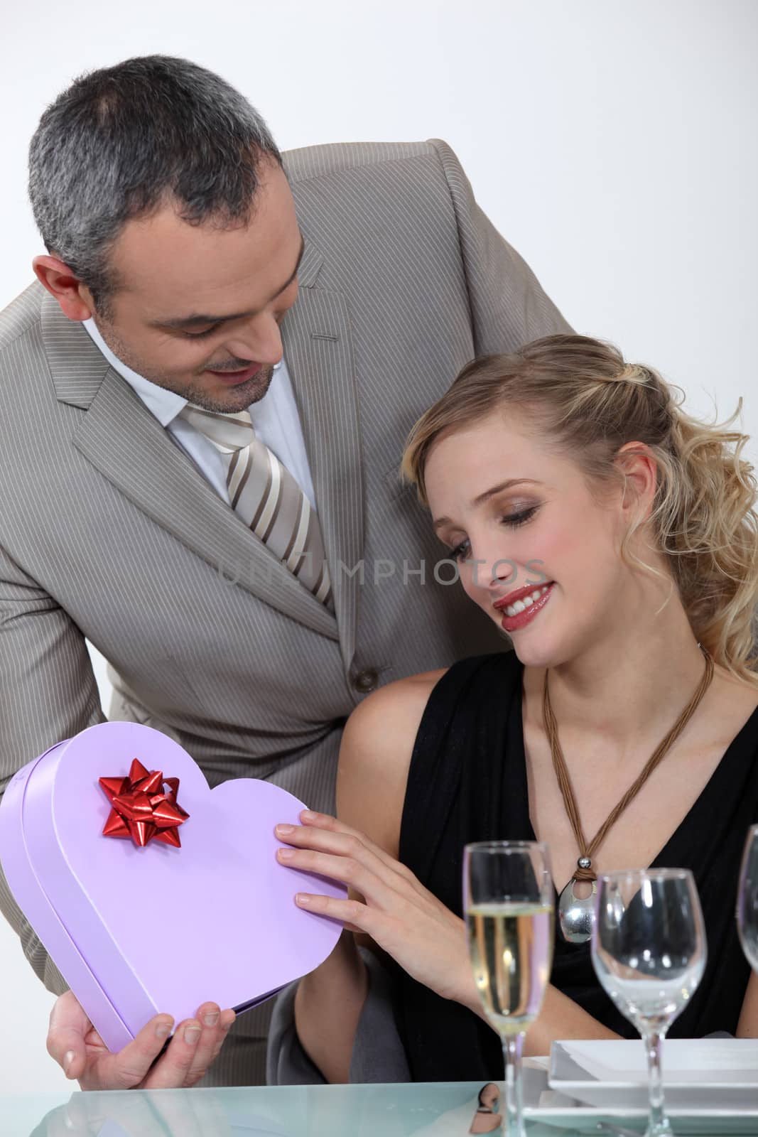 blond receiving gift from boyfriend at romantic dinner